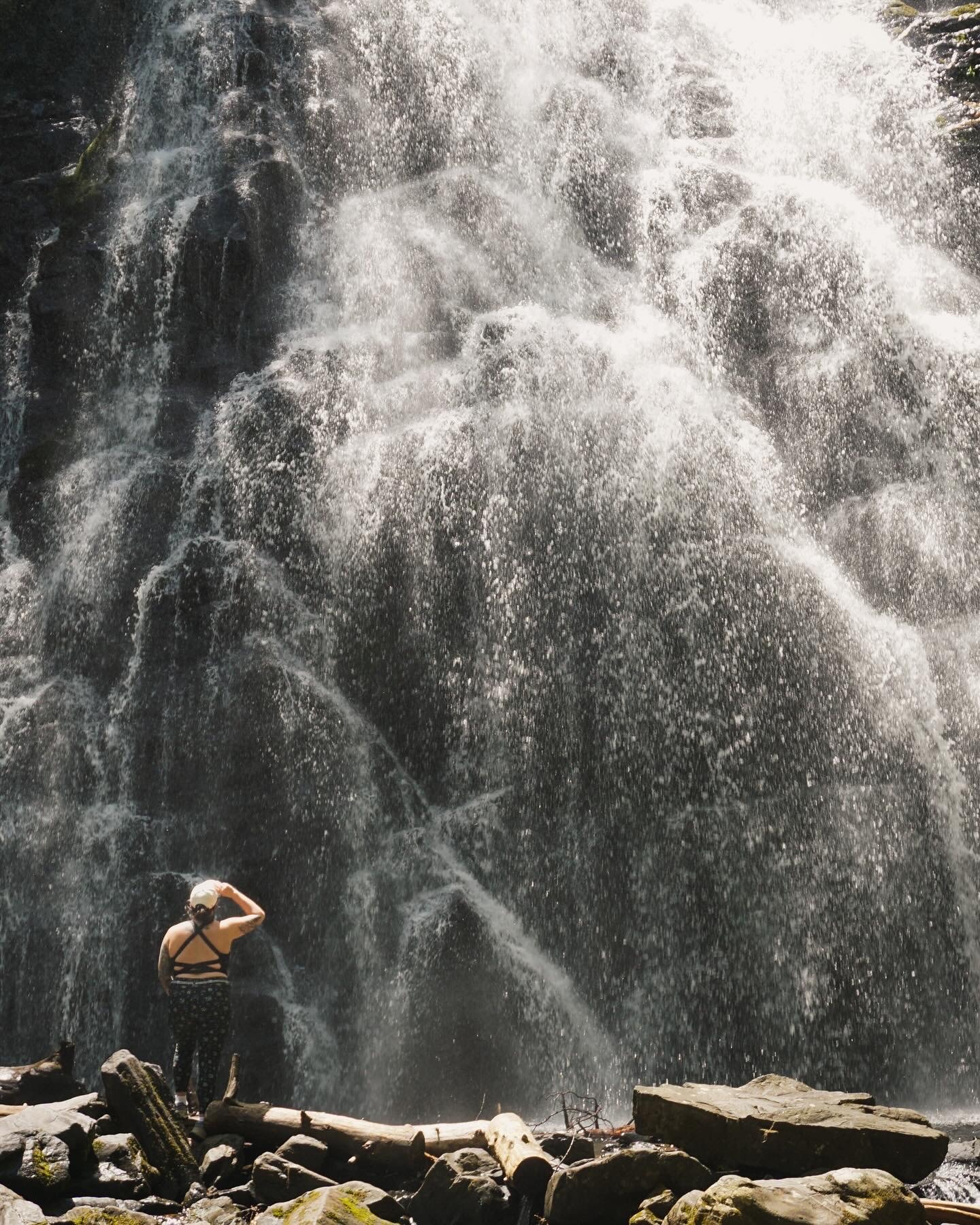 Beautiful view of Anna in front of a large cascading waterfall while looking up