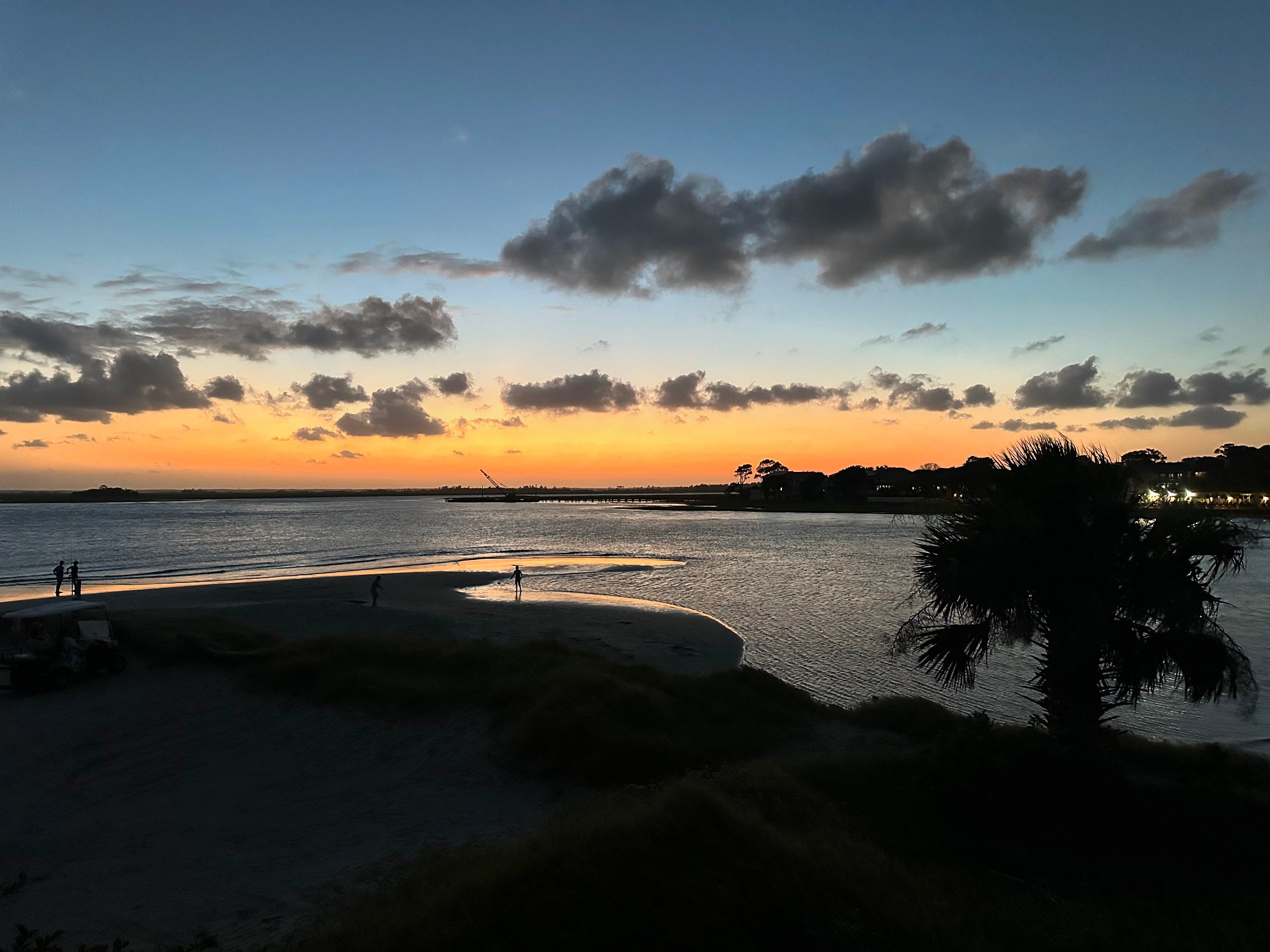 View of the ocean and a beautiful orange sunset with few clouds in the sky