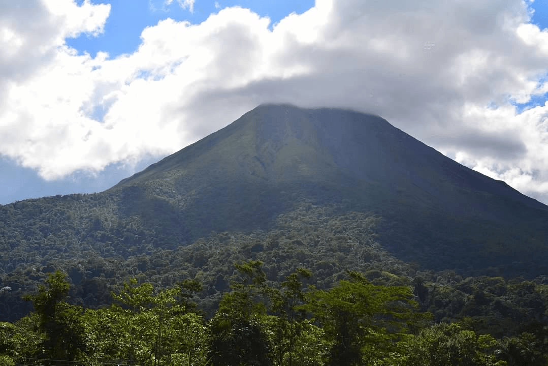 View of a lush green mountain landscape under partly cloudy skies