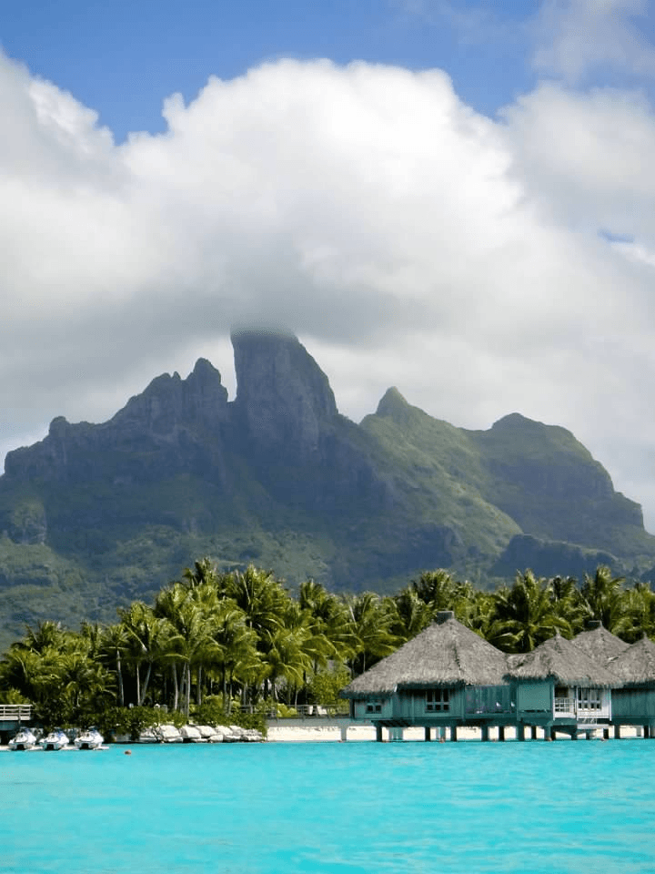 Beautiful view of bright blue ocean water and overwater bungalows in Bora Bora