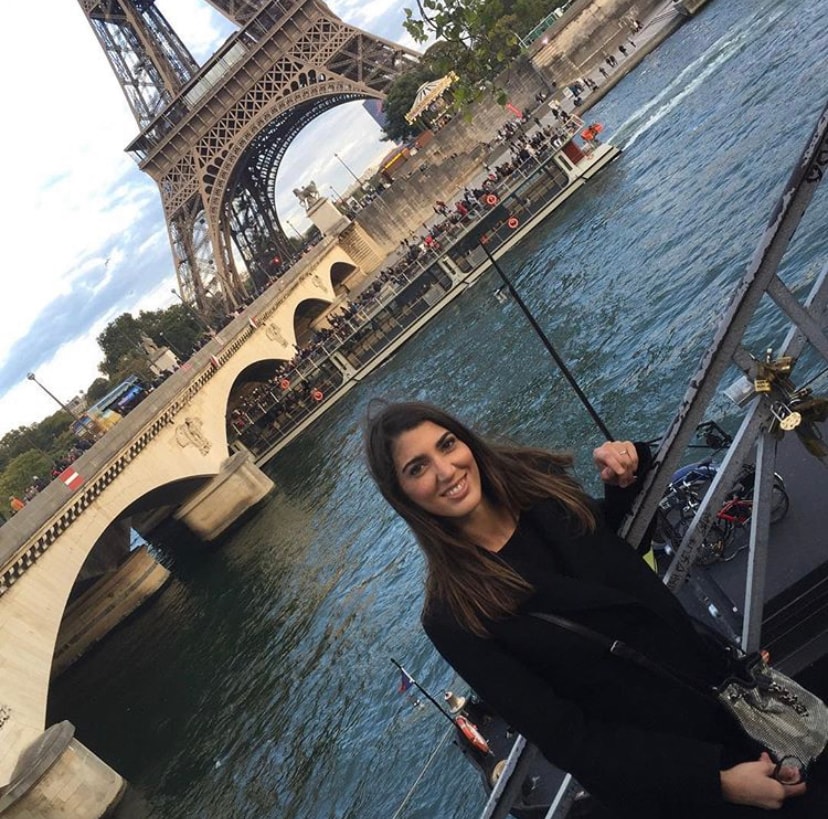 Advisor posing on a railing in front of the Eiffel Tower. 