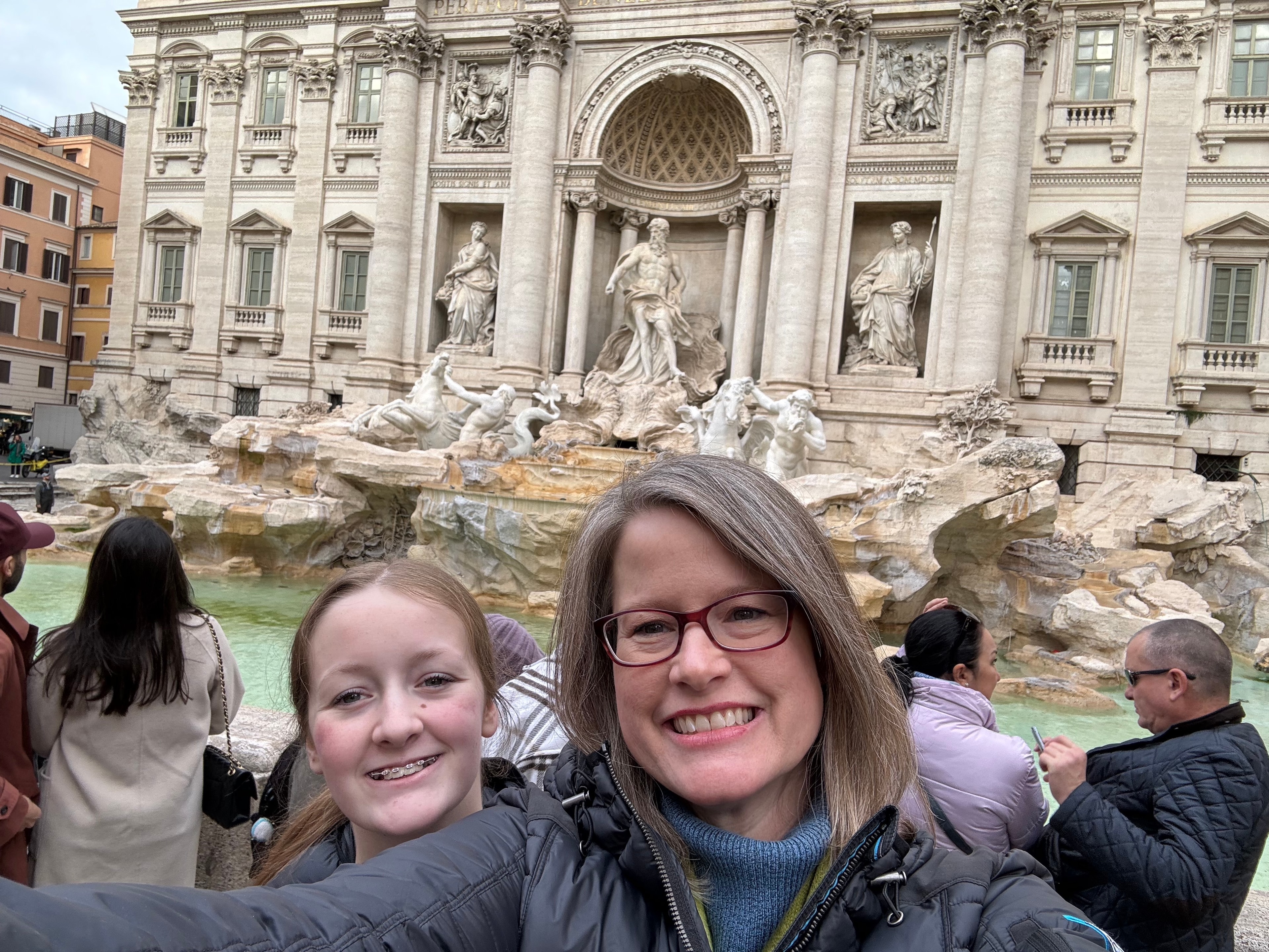 Advisor taking a selfie with her daughter in front of the Trevi Fountain in Rome