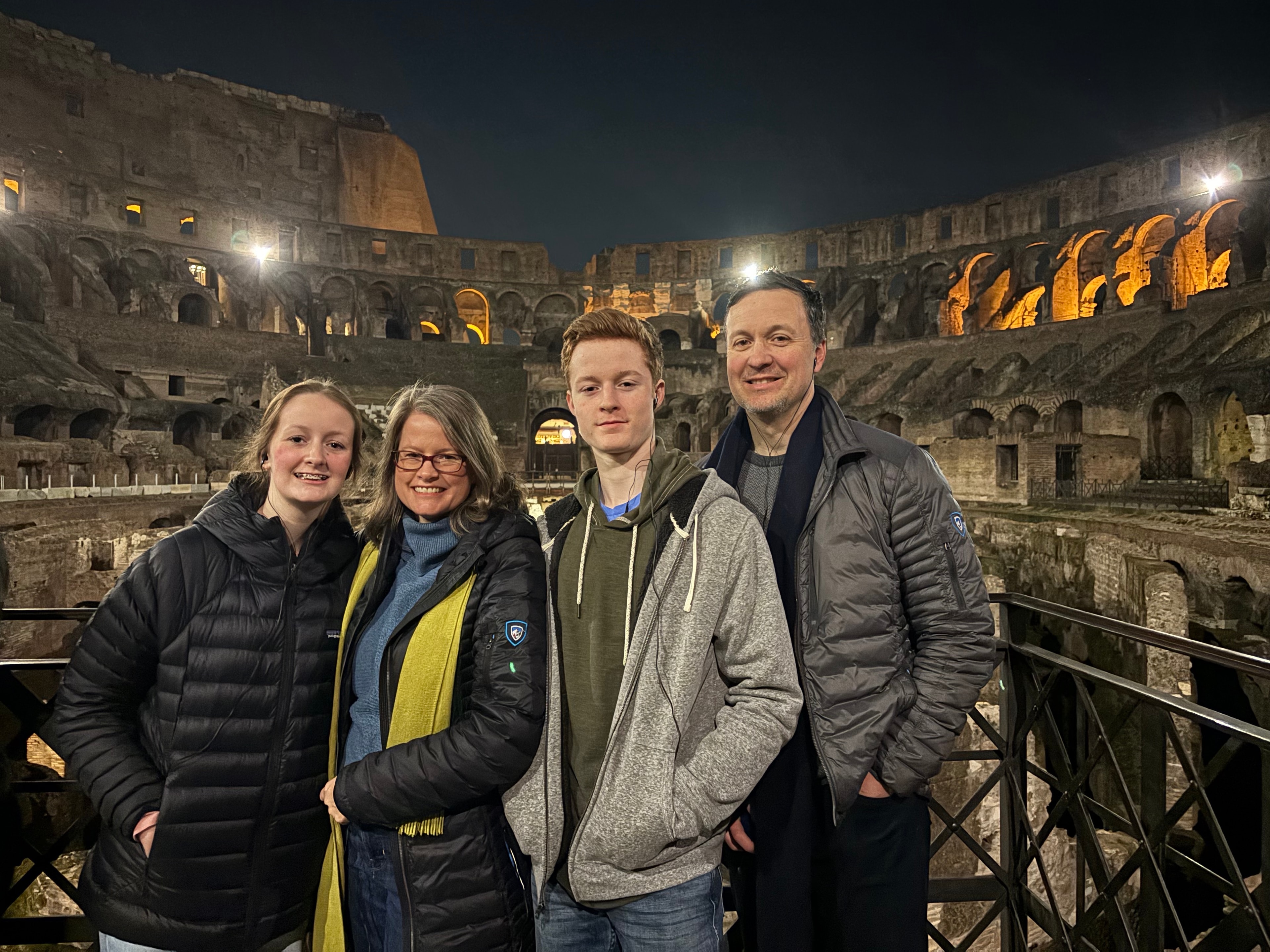 Advisor and her family posing for a photo inside the Colosseum at night