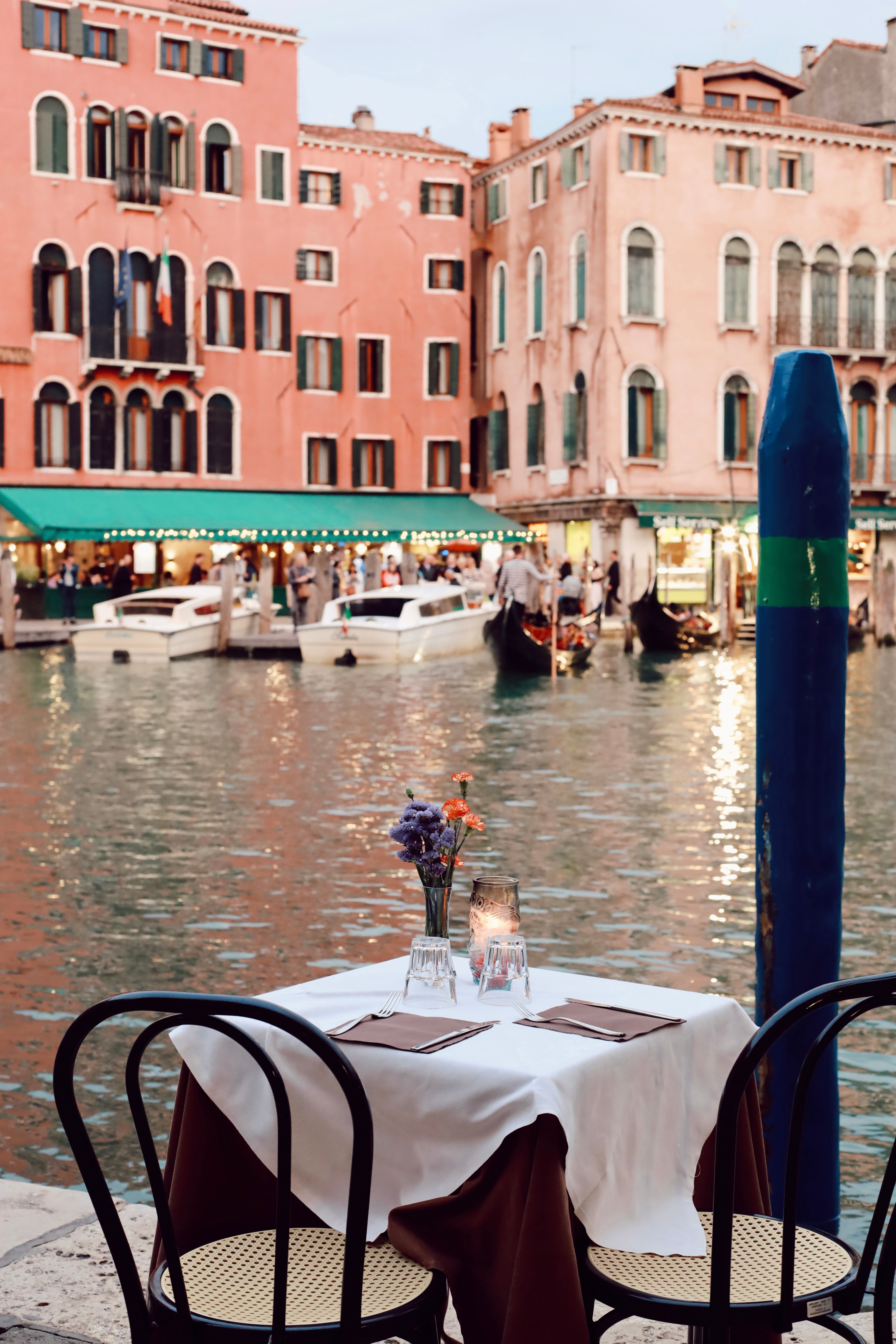 A view of a table at a restaurant with a body of water in the distance. 