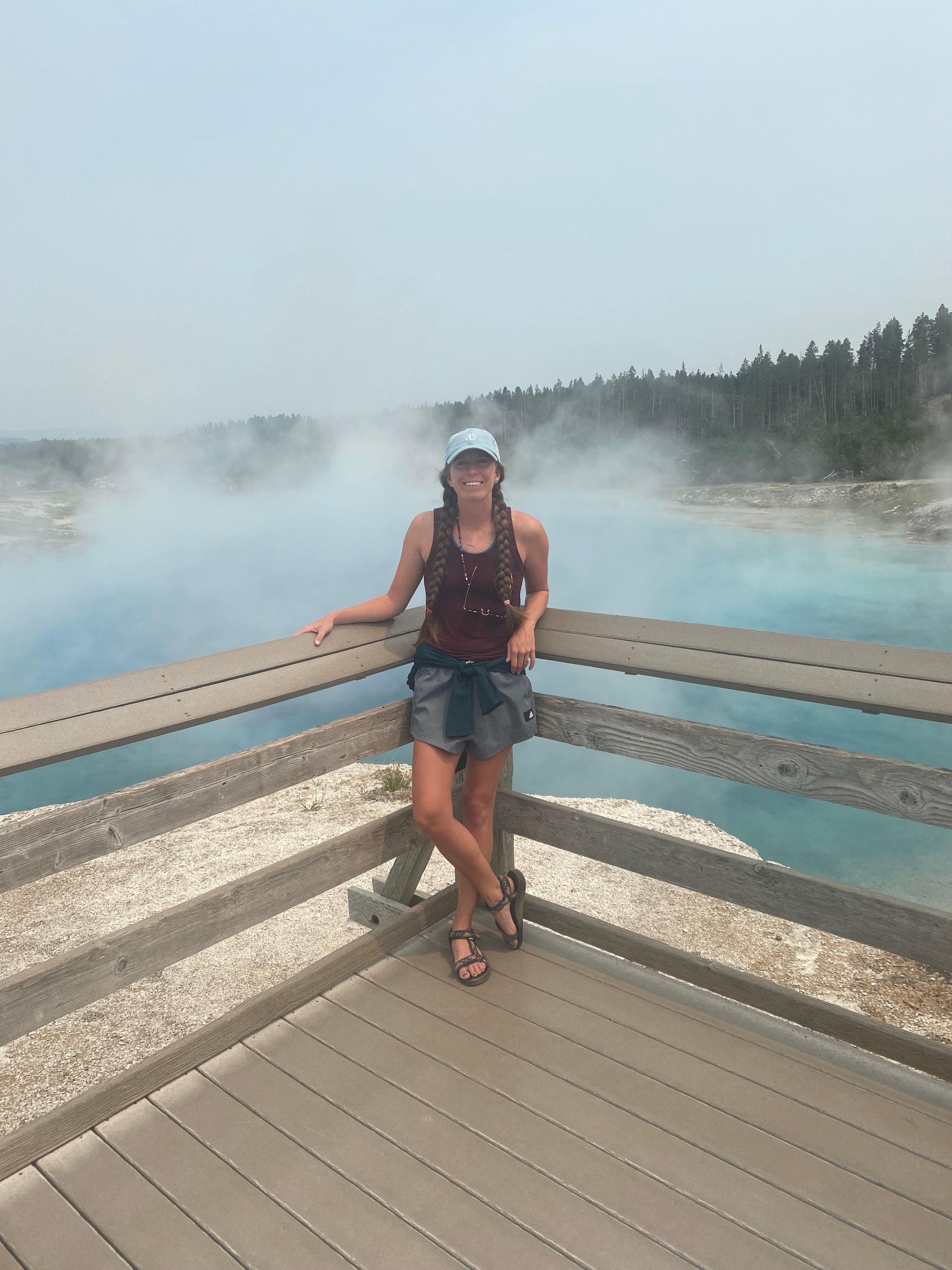 Advisor posing on a wooden deck with a body of water in the distance. 