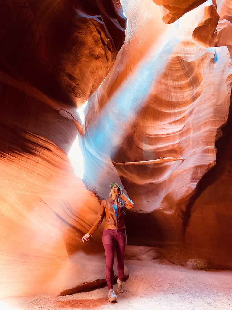 Advisor in athletic gear posing in between the red rocks of Antelope Canyon