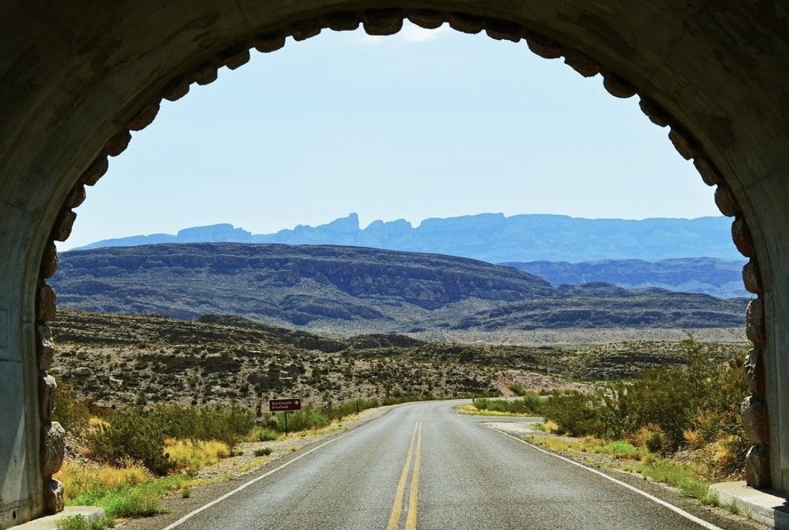 An empty road stretches toward the horizon on a clear day. 