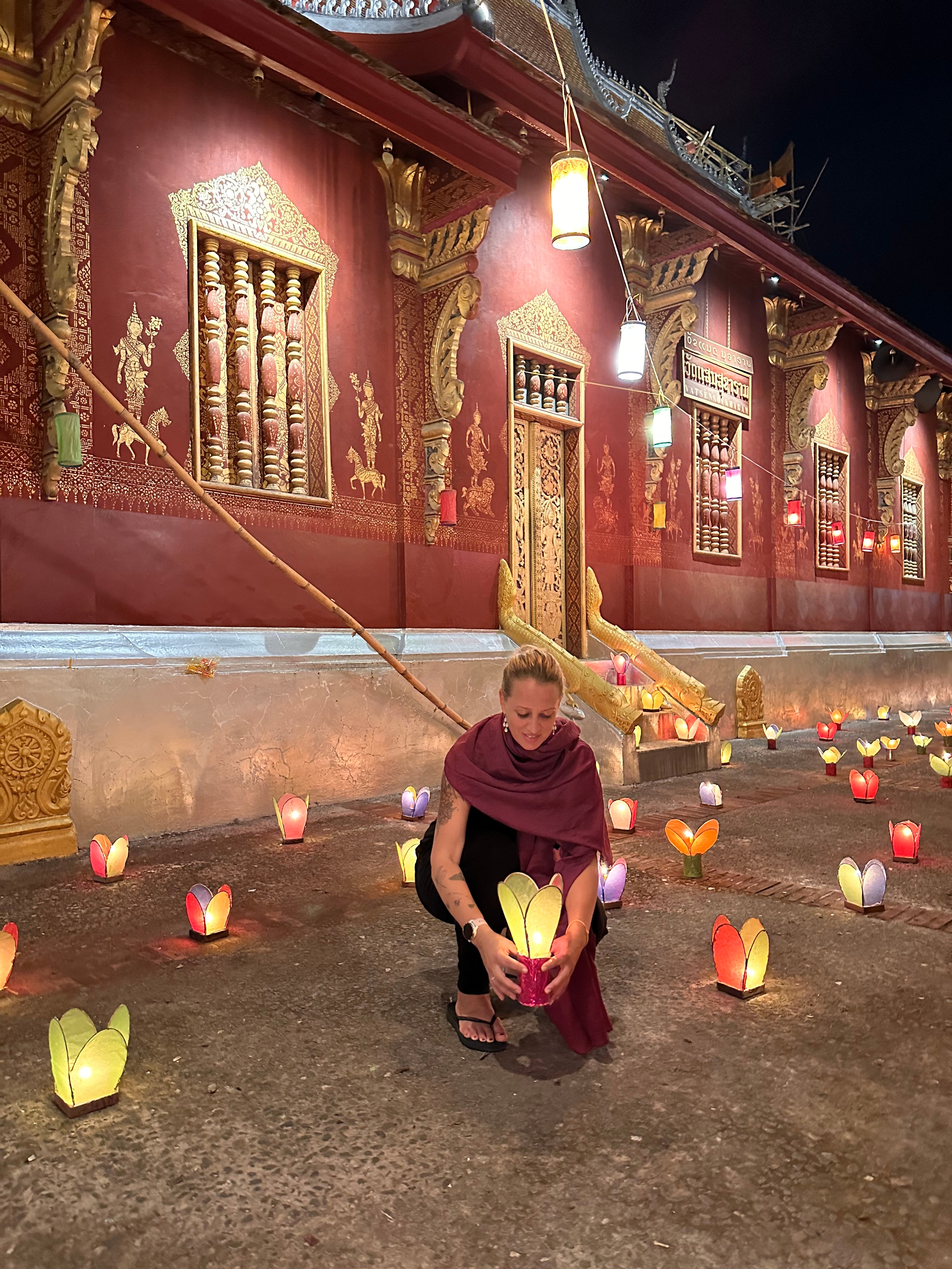 View of advisor holding a paper lantern outdoors on a street with many other lanterns surrounding her