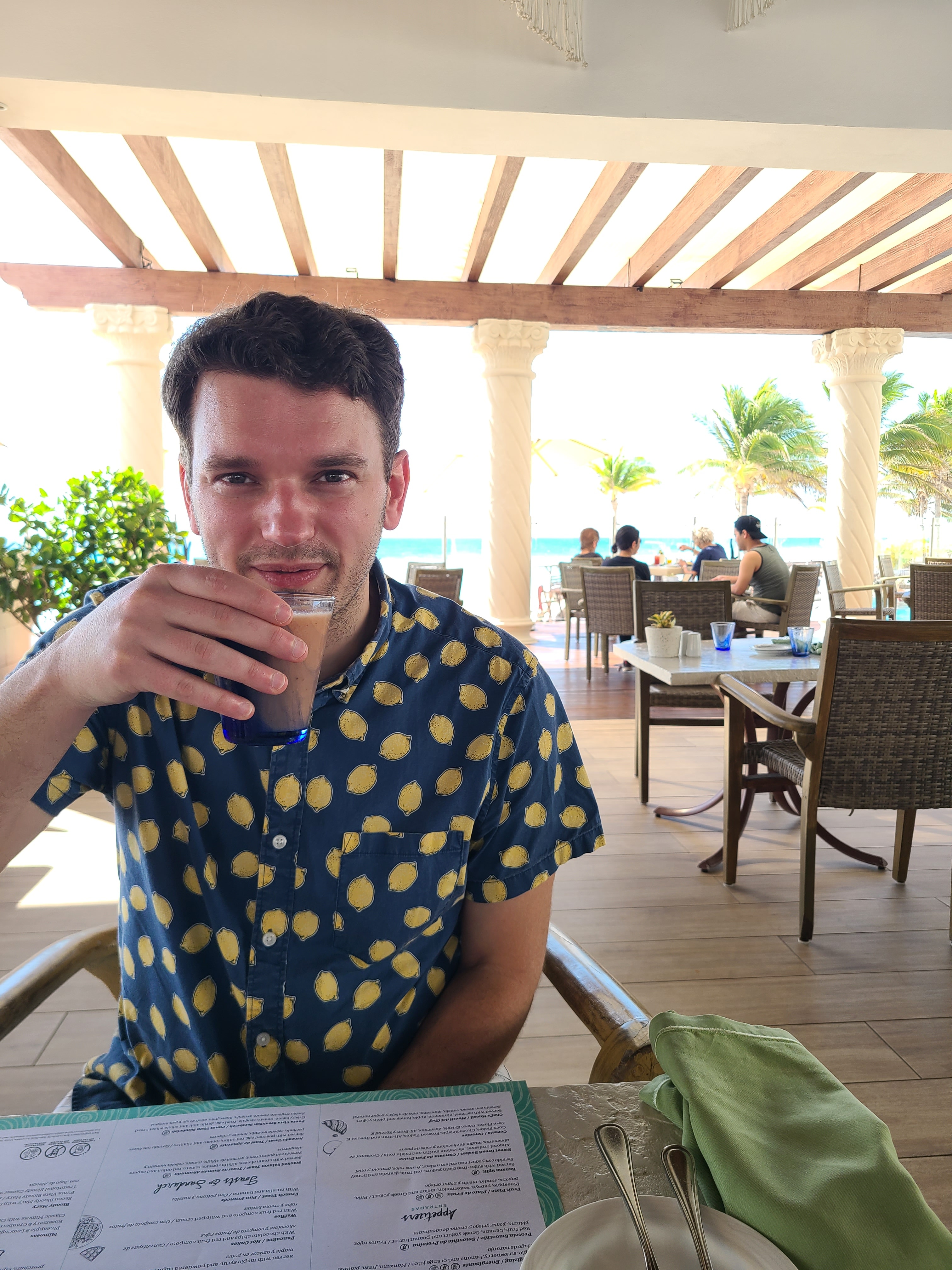 Advisor at a restaurant table with drink raised to his mouth