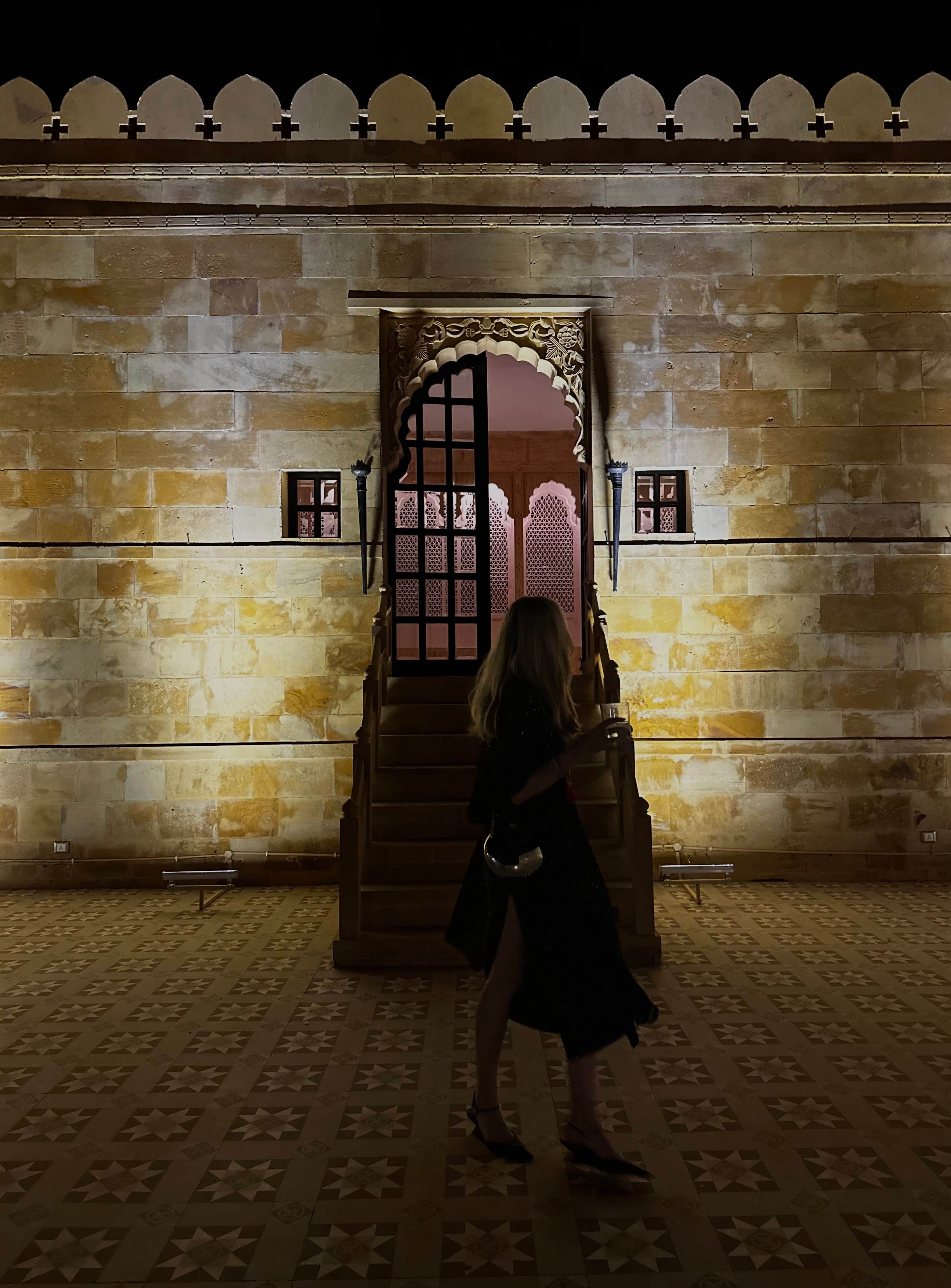 Advisor in silhouette on a street in front of a stone wall lit up at night