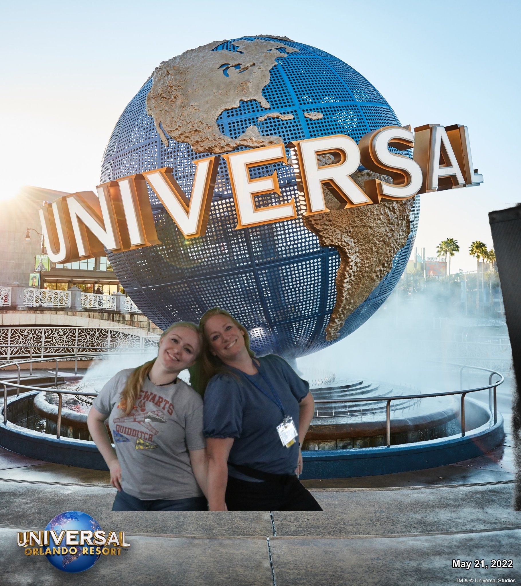 Advisor and a woman holding hands and posing in front of the Universal globe fountain