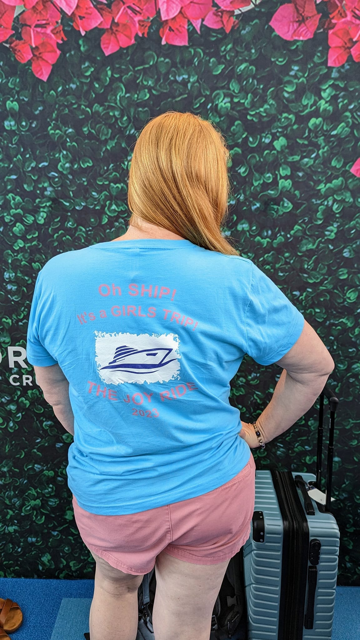 Advisor in a blue shirt posing with hand on her hip and back to the camera