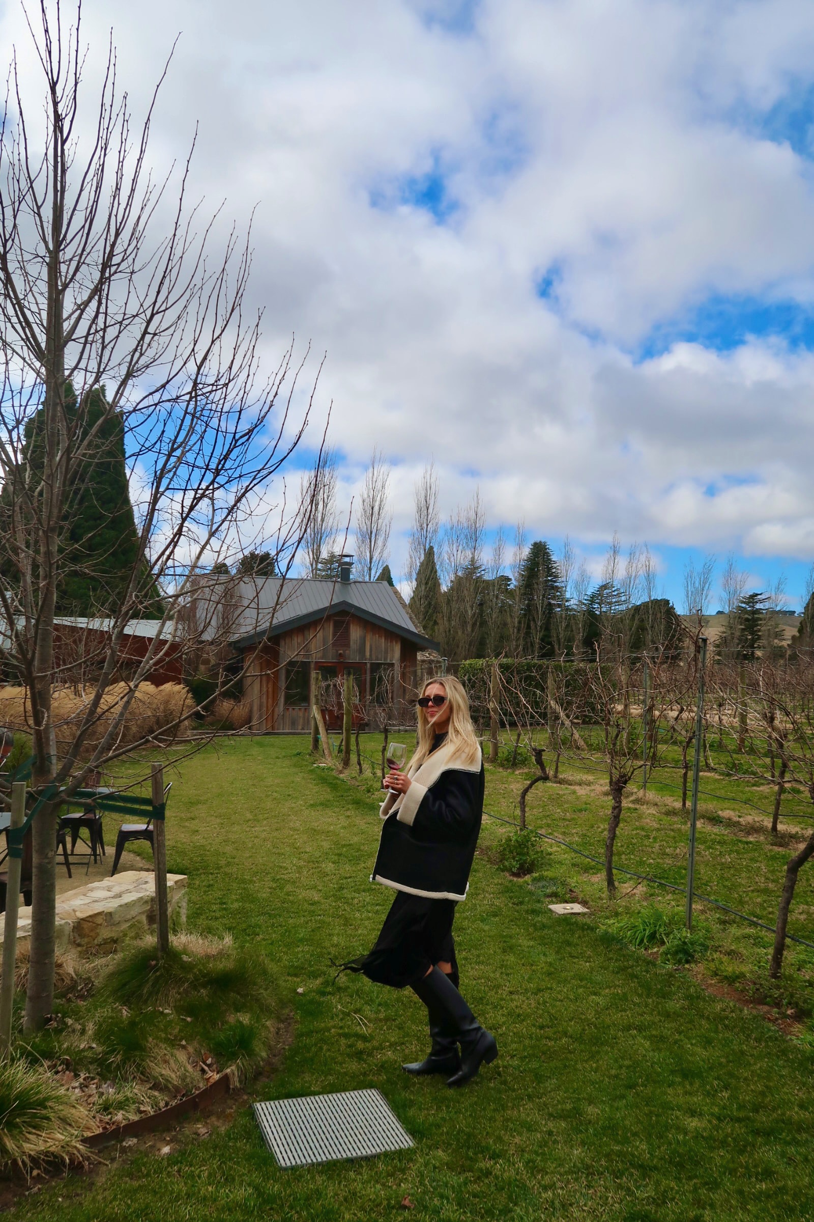 Advisor standing in a vineyard and holding a glass of wine