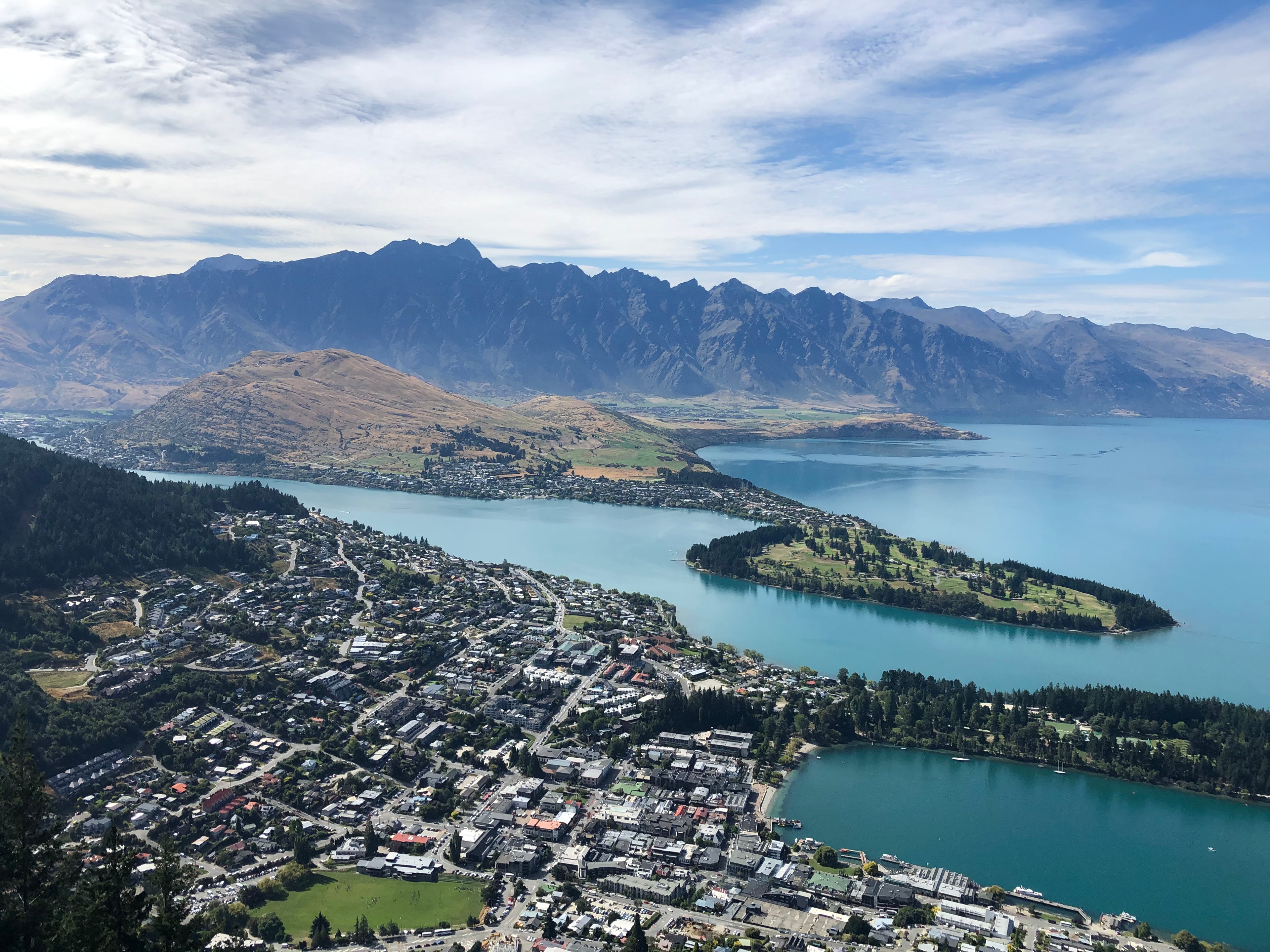 Aerial view of a coastal city with stunning mountains in the distance