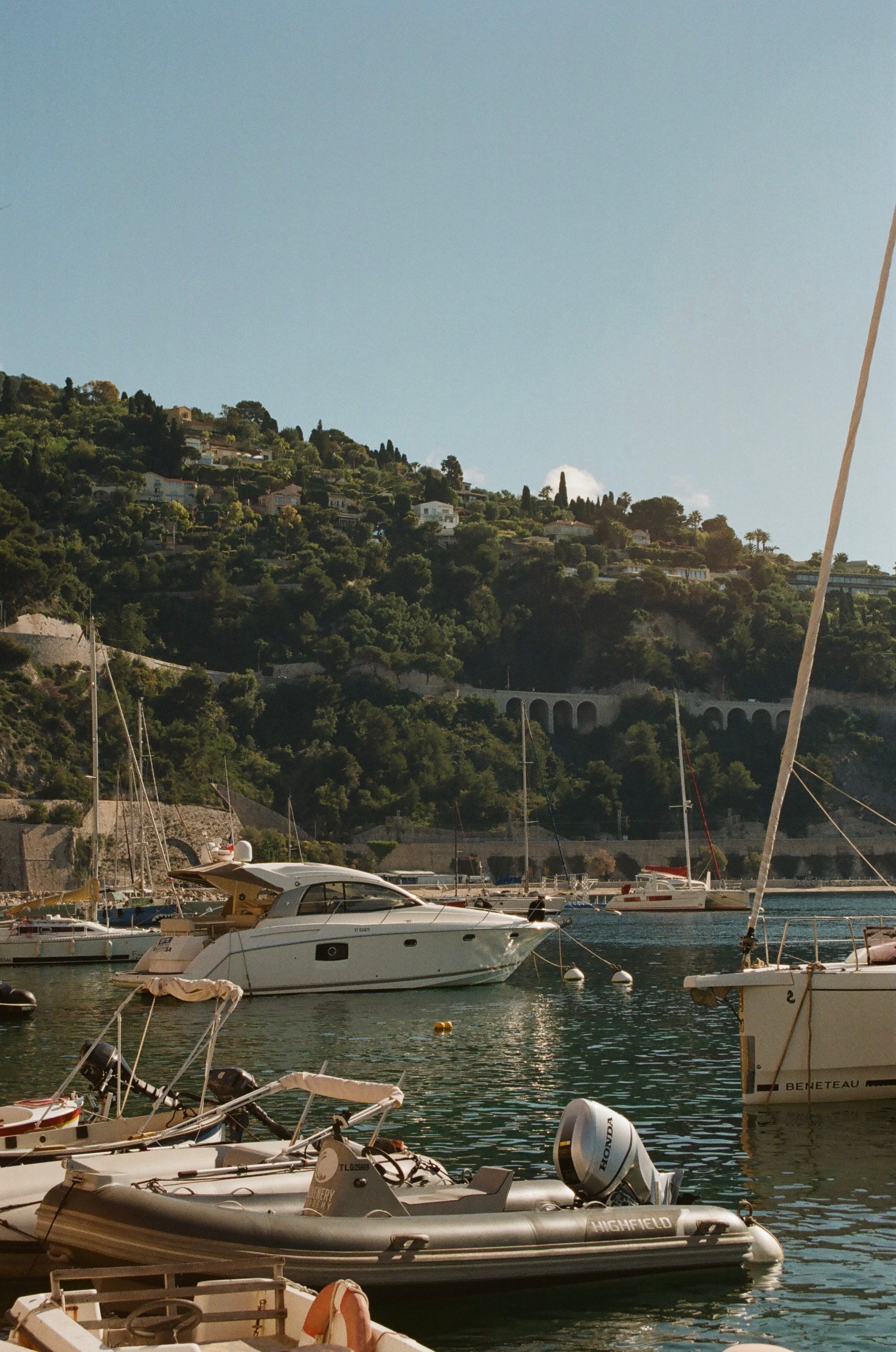 Small boats docked in a small port under clear skies