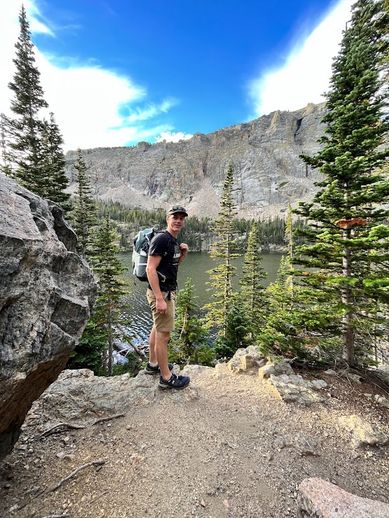 View of advisor on a hike through a beautiful mountain range dotted with pine trees