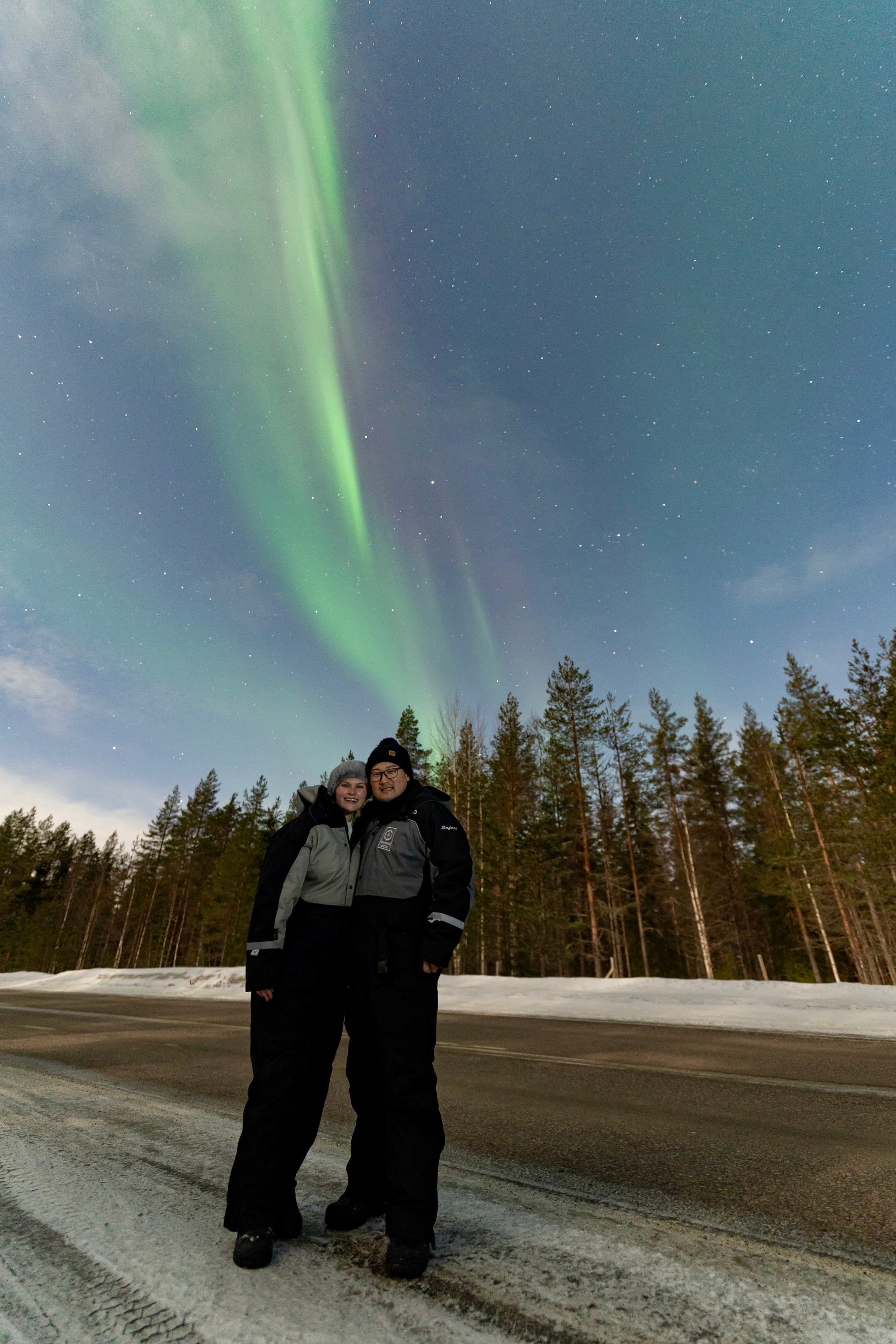 Advisor and partner in winter clothing under the northern lights