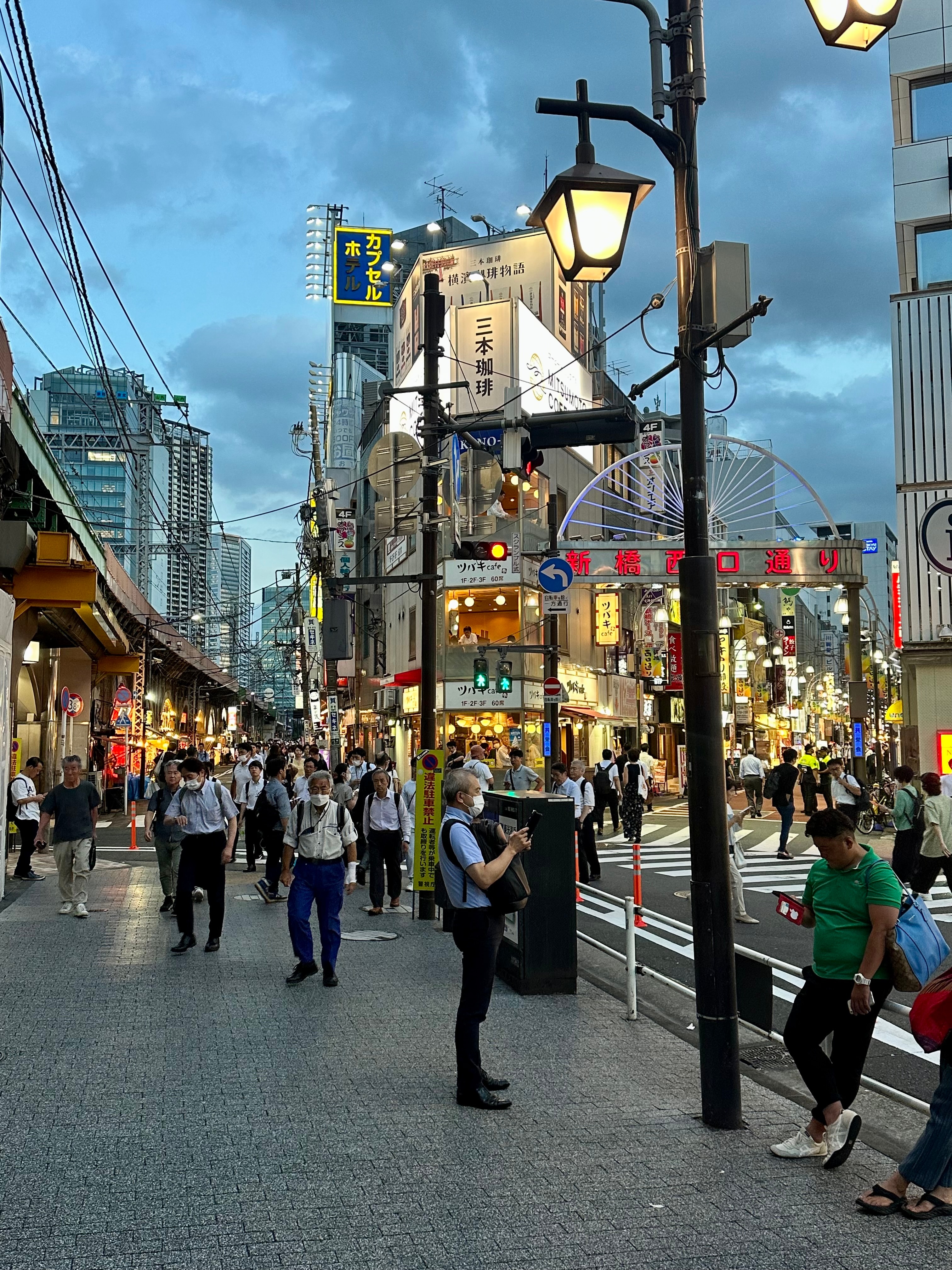 View of a city street decorated with lights at dusk on a cloudy evening