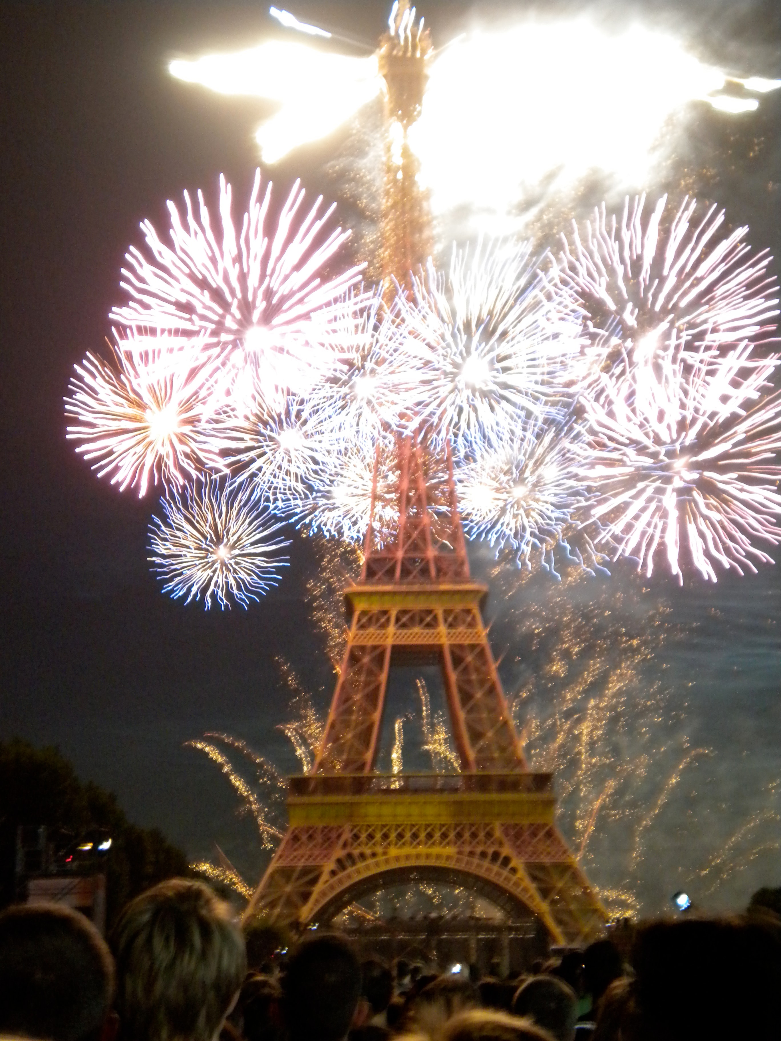 Fire works lighting up the sky around the Eiffel Tower at night.