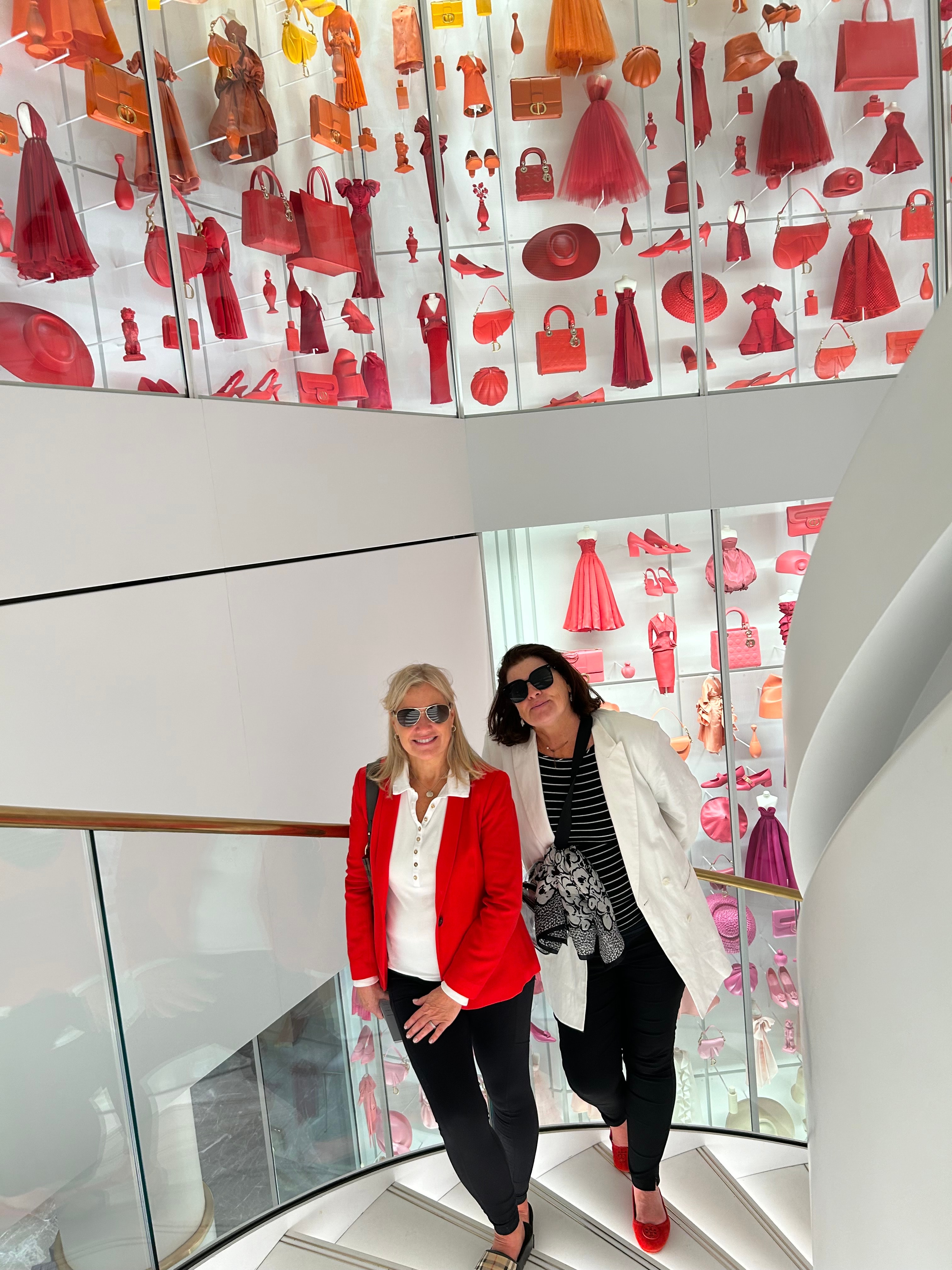 Advisor and a friend walking up a white spiral staircase indoors