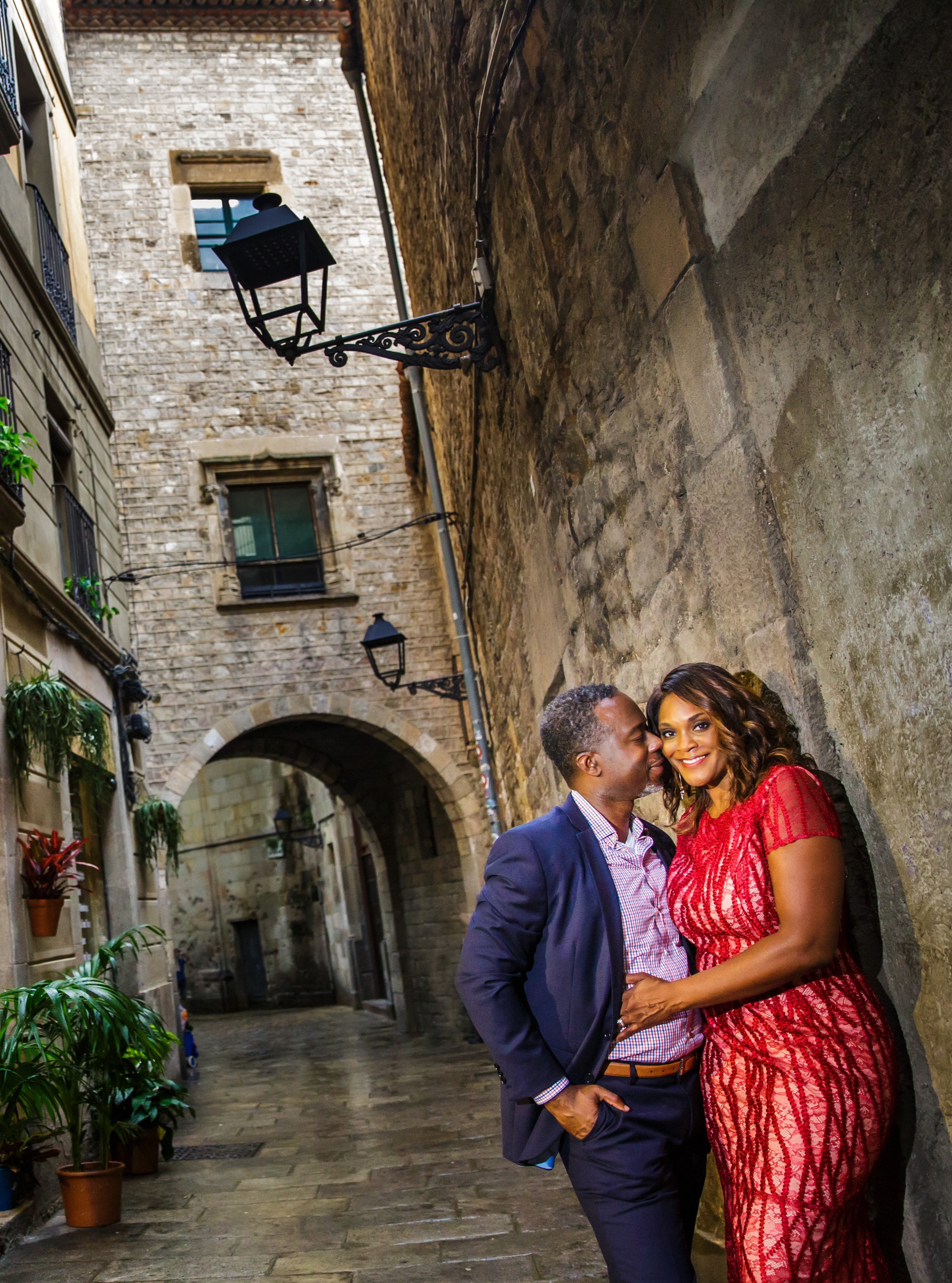 Advisor and wife in evening wear posing in an embrace on a pretty stone street