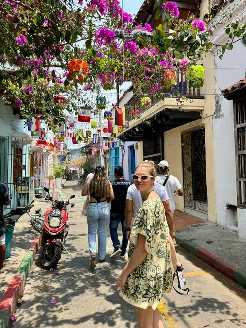 Advisor walking on a narrow street covered with purple flowers