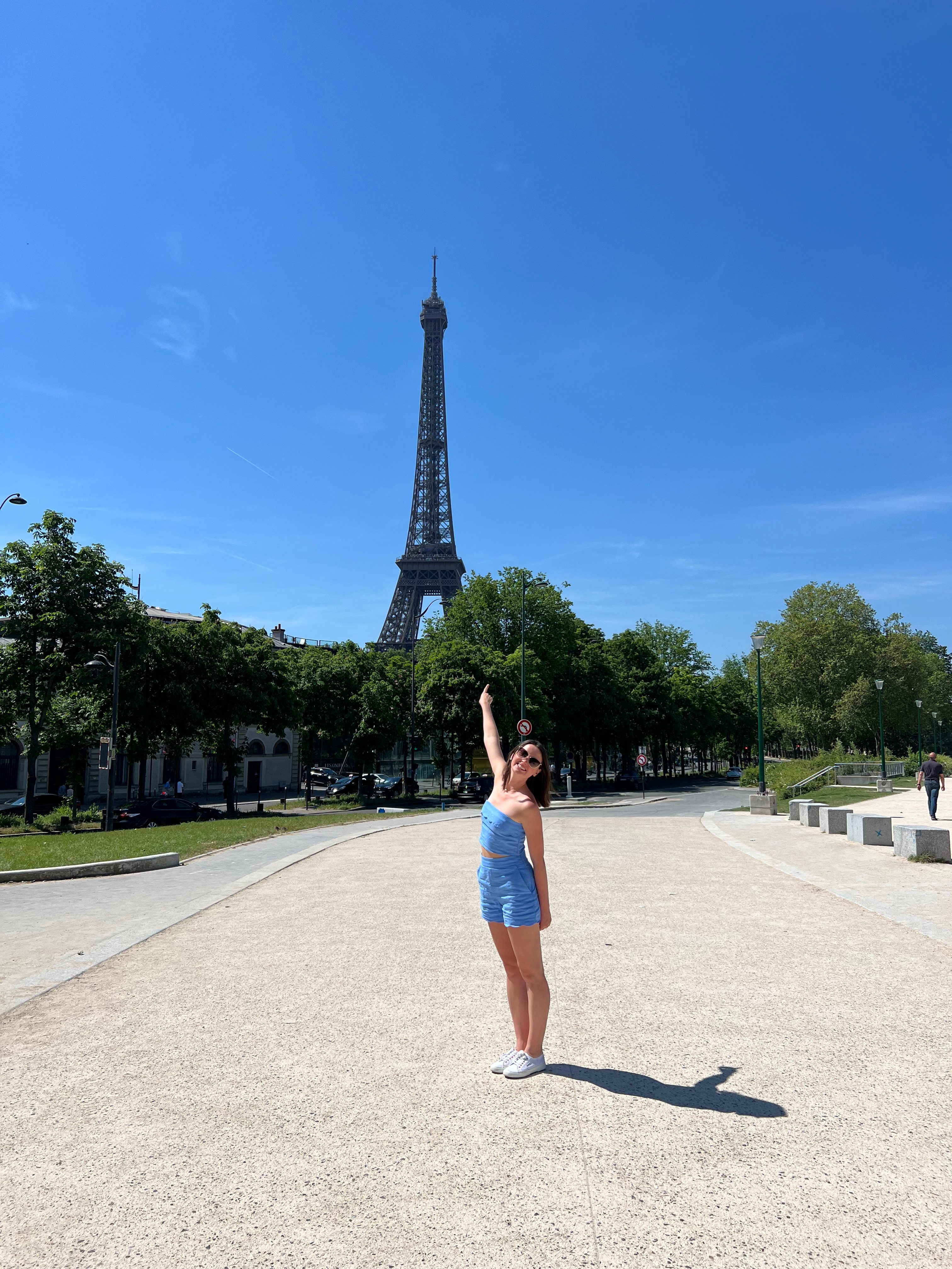 Advisor posing with the Eiffel Tower visible behind her on a sunny day