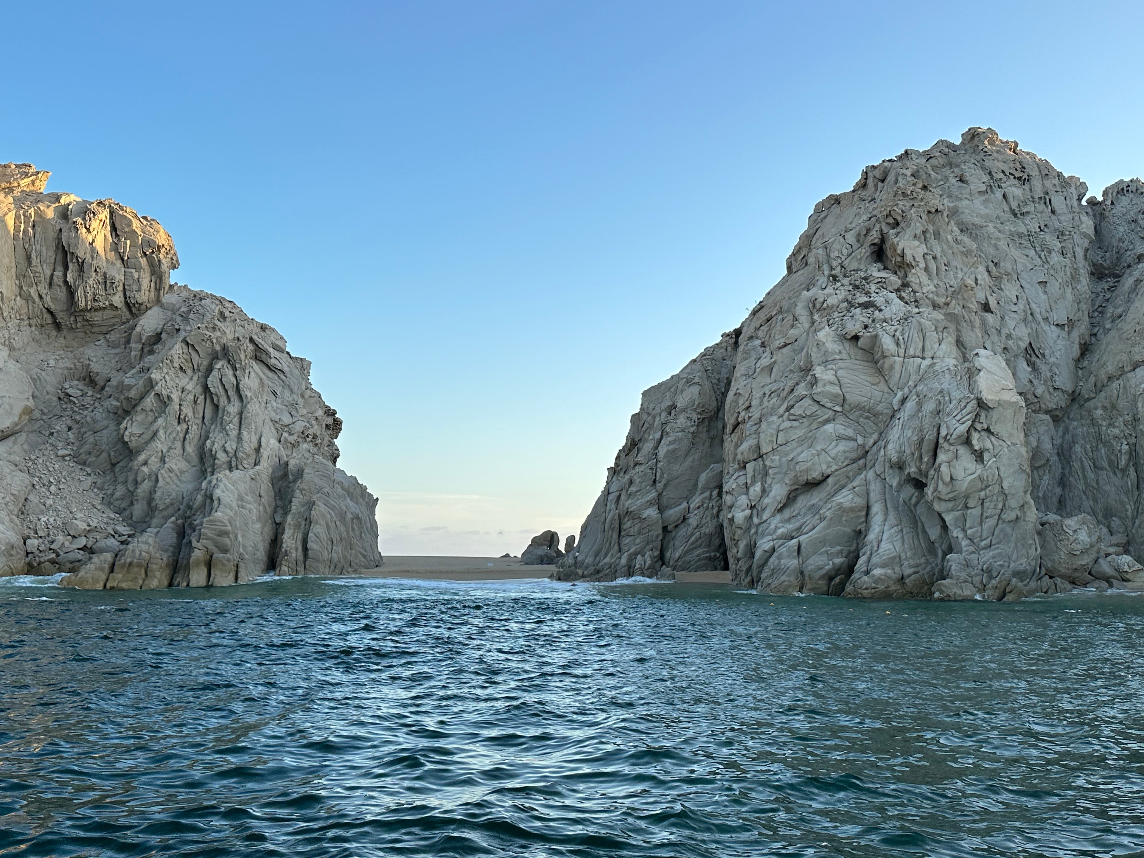 Two mountain crags face each other in a waterway at dusk. 