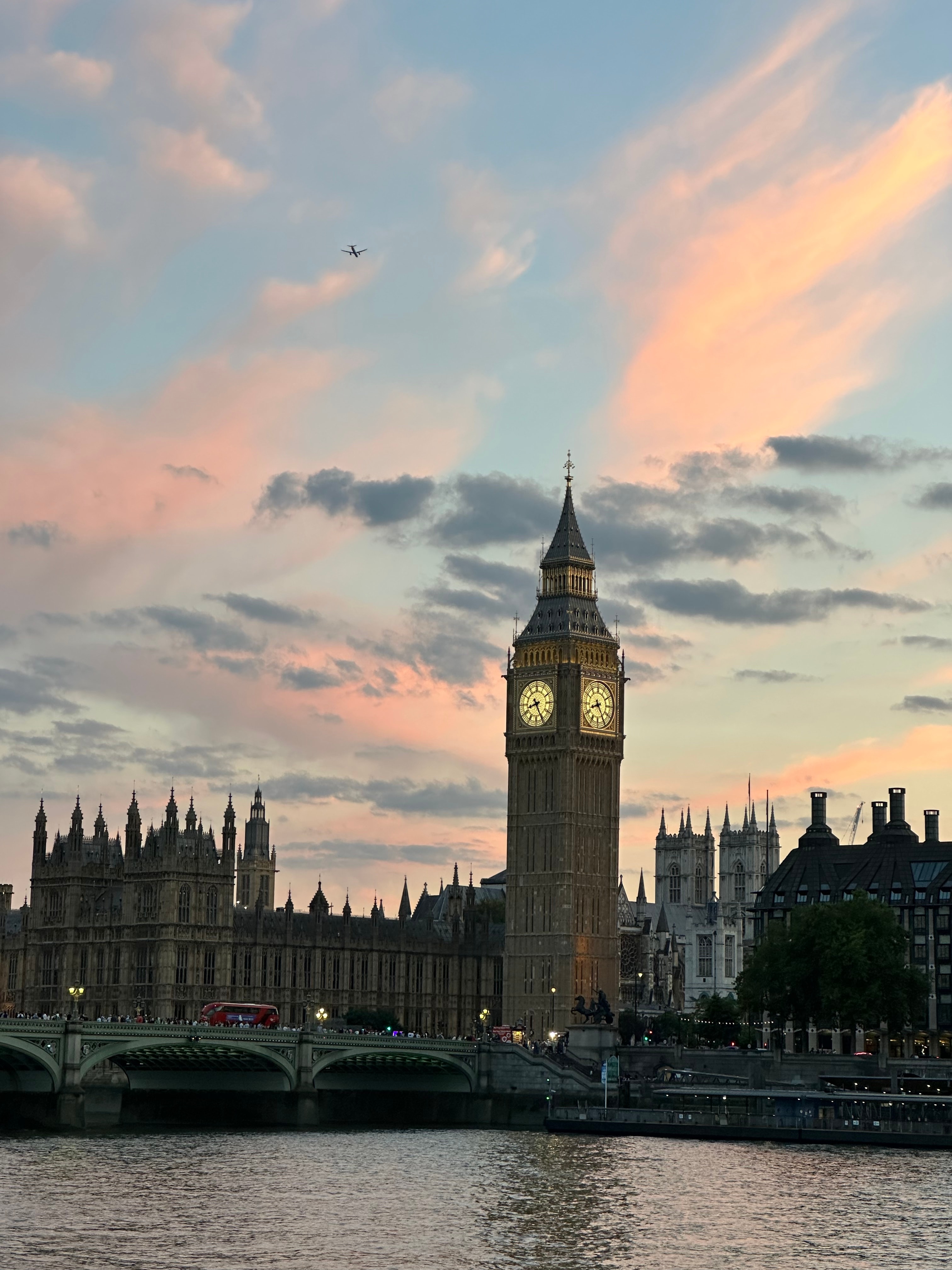 A body of water with a clocktower across the way at dusk. 