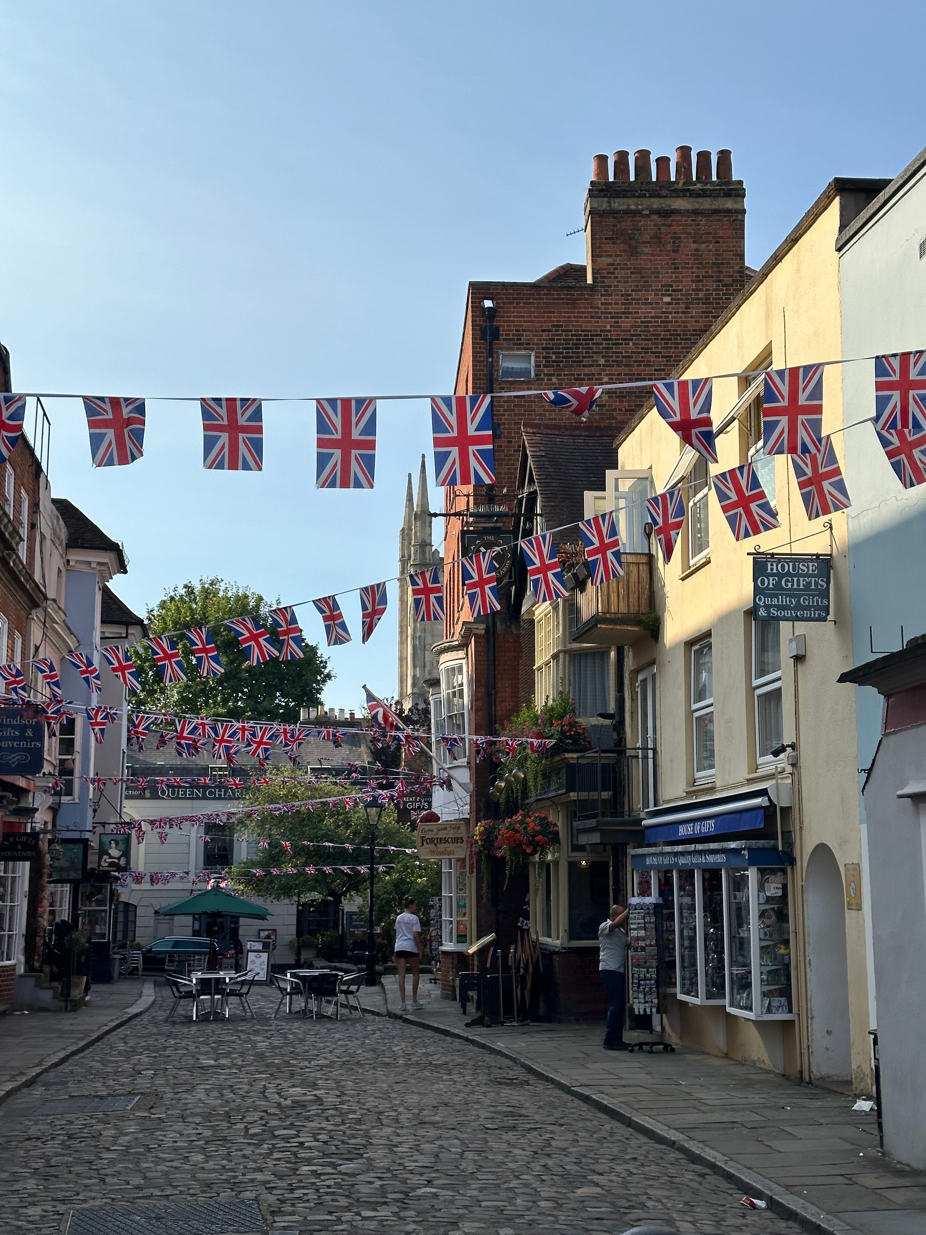 A view of the street in a quaint town with flags during the day time.