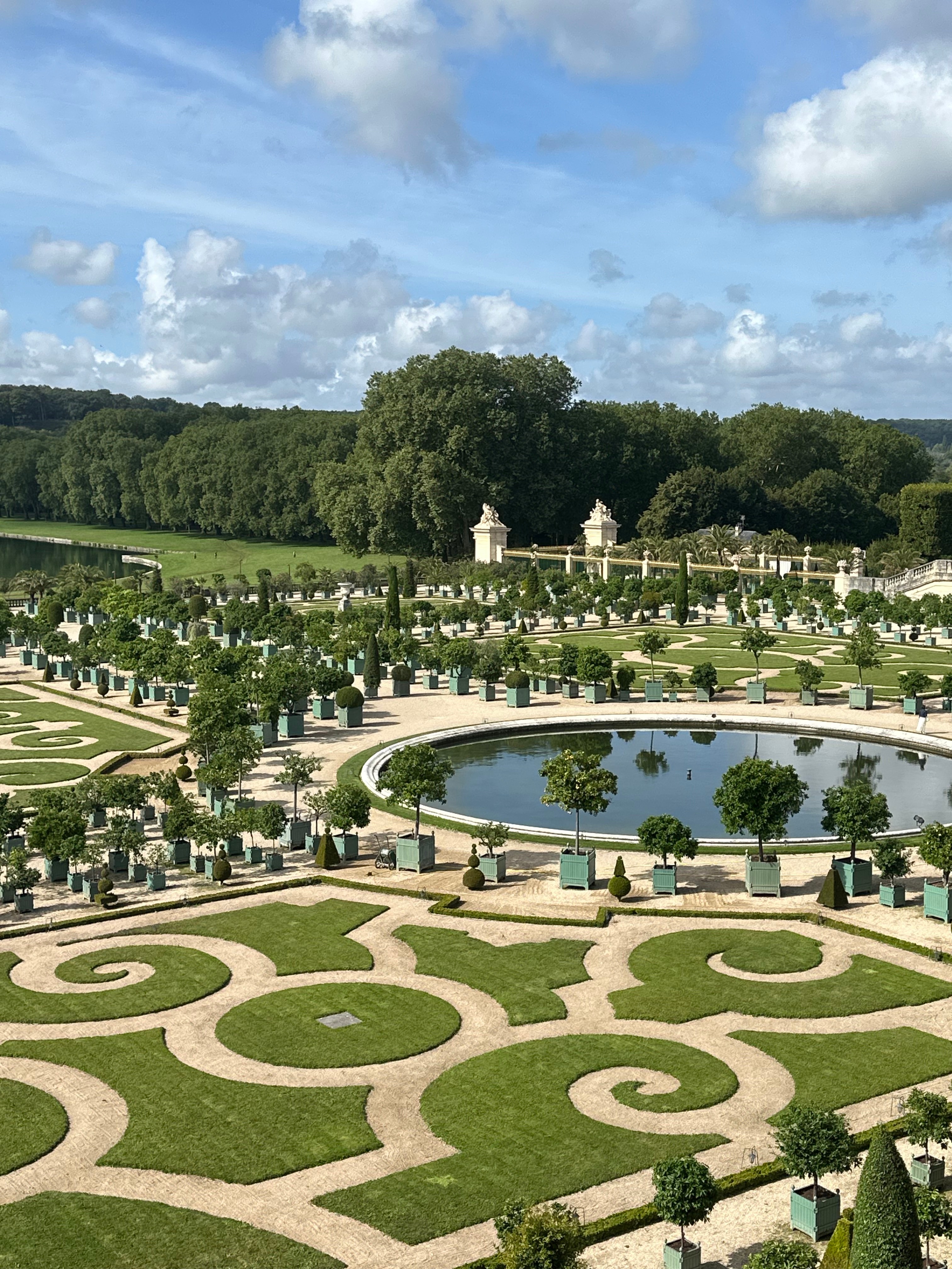 A view of a waterfountain surrounded by a walking path during the day.