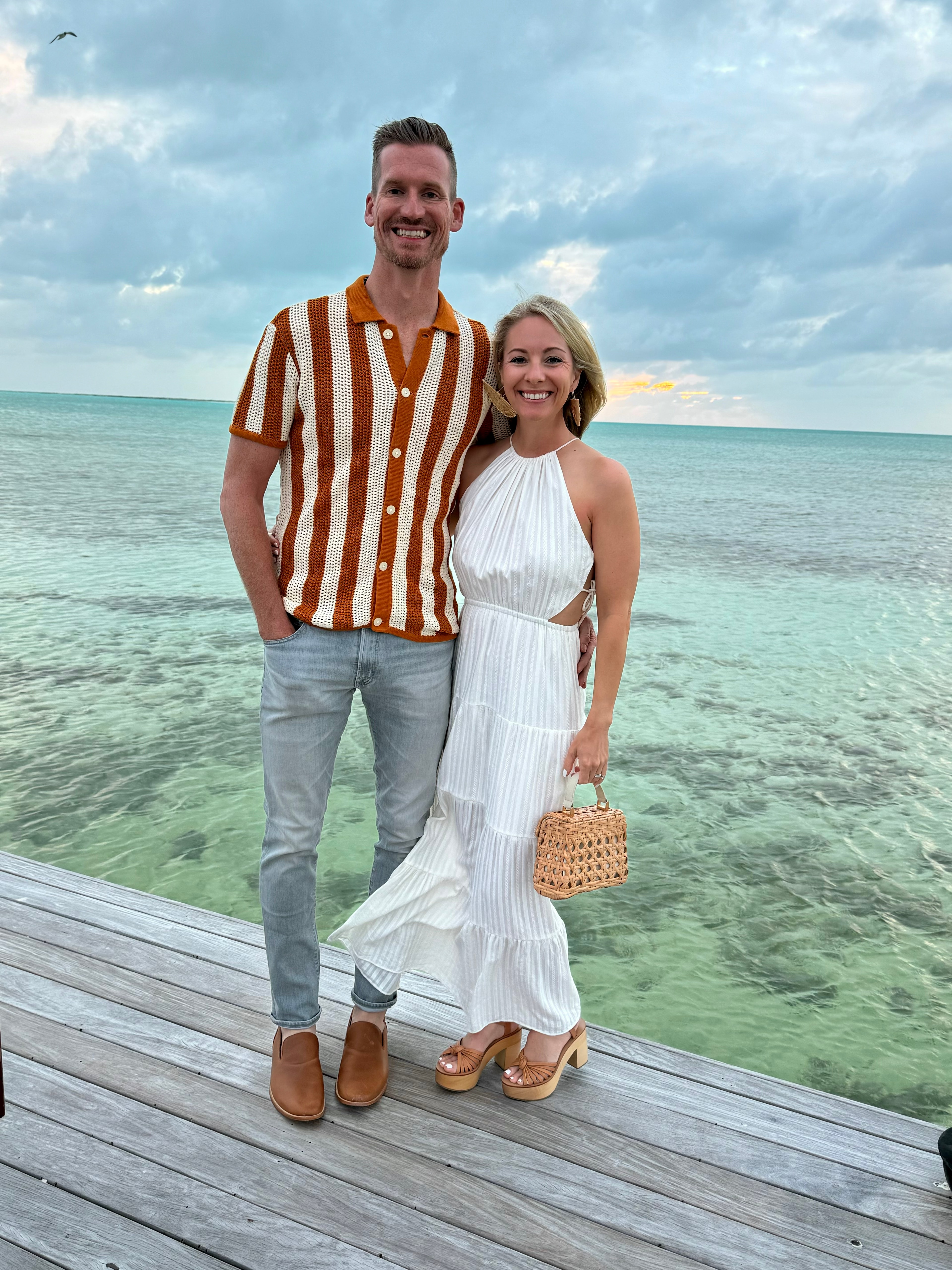 A couple posing on the beach during the daytime. 