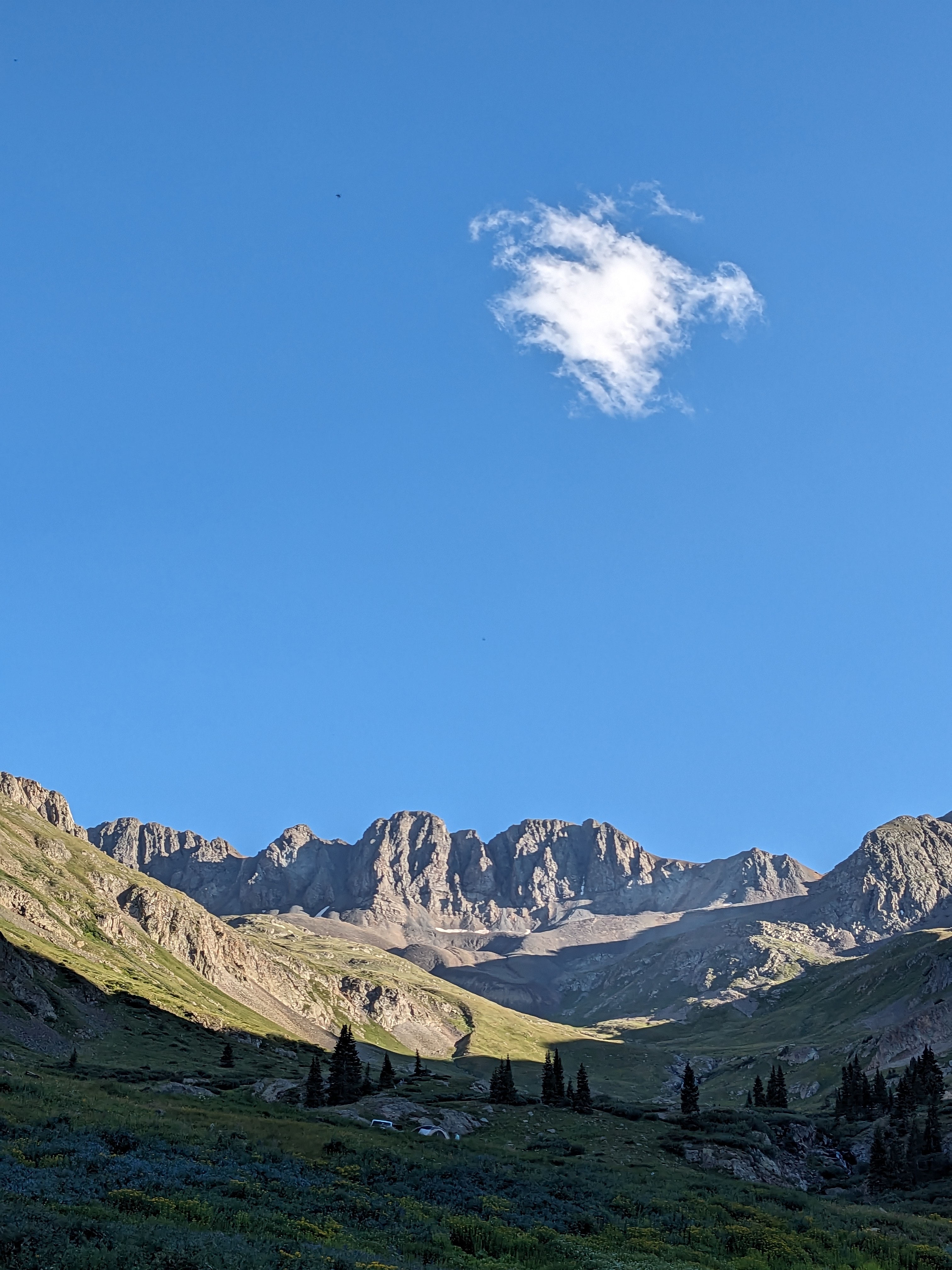 A view of rocky mountains beneath a clear blue sky. 