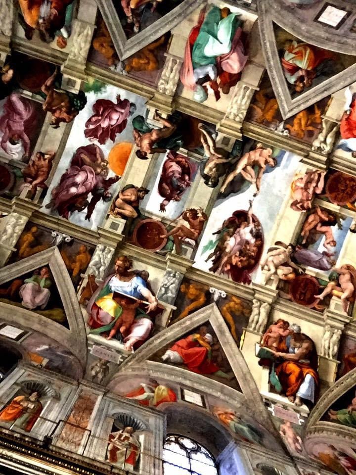 View of an ornately decorated church ceiling with figures of angels and saints