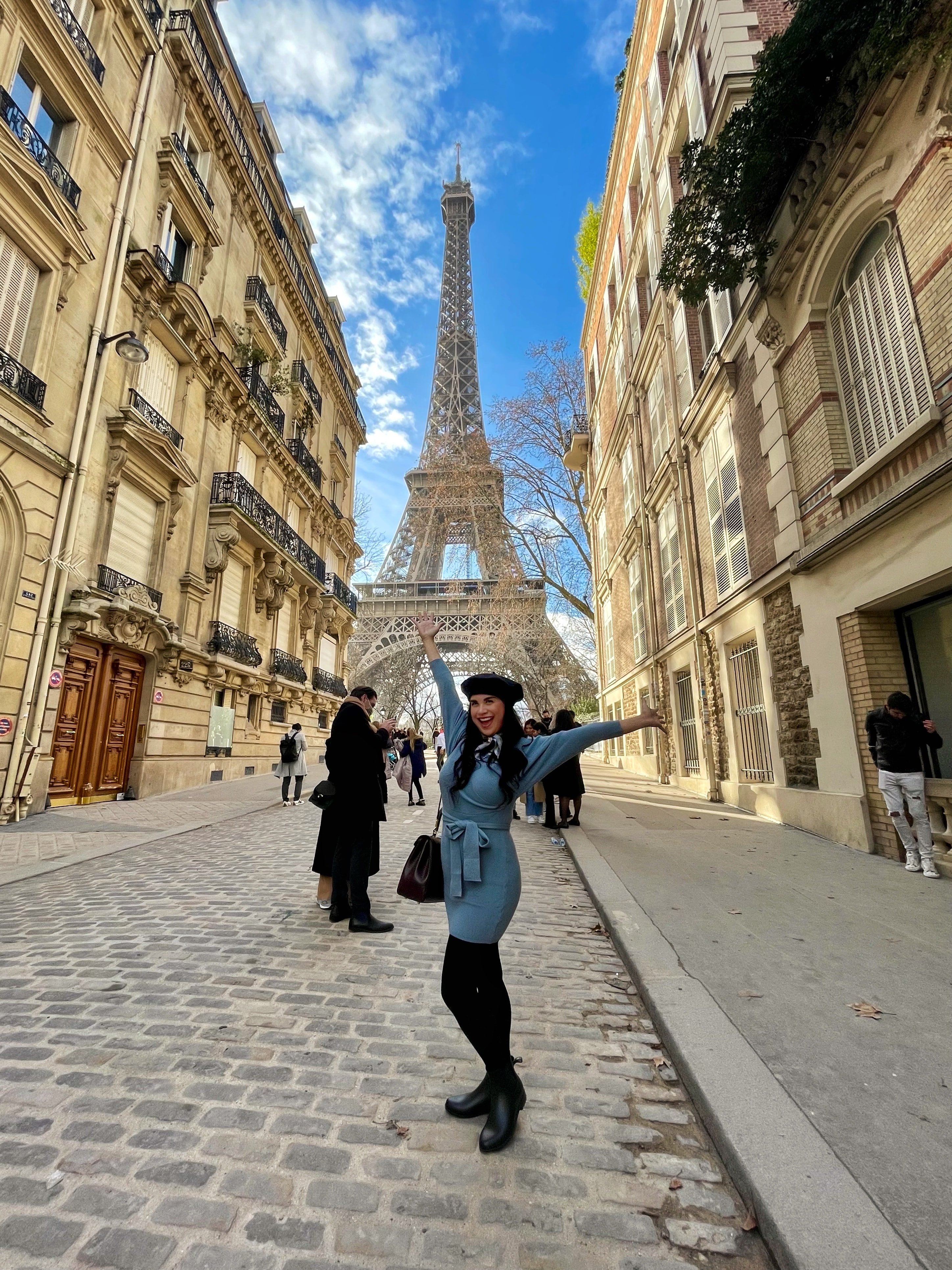 Advisor posing on the street during a sunny day with the Eiffel Tower in the background