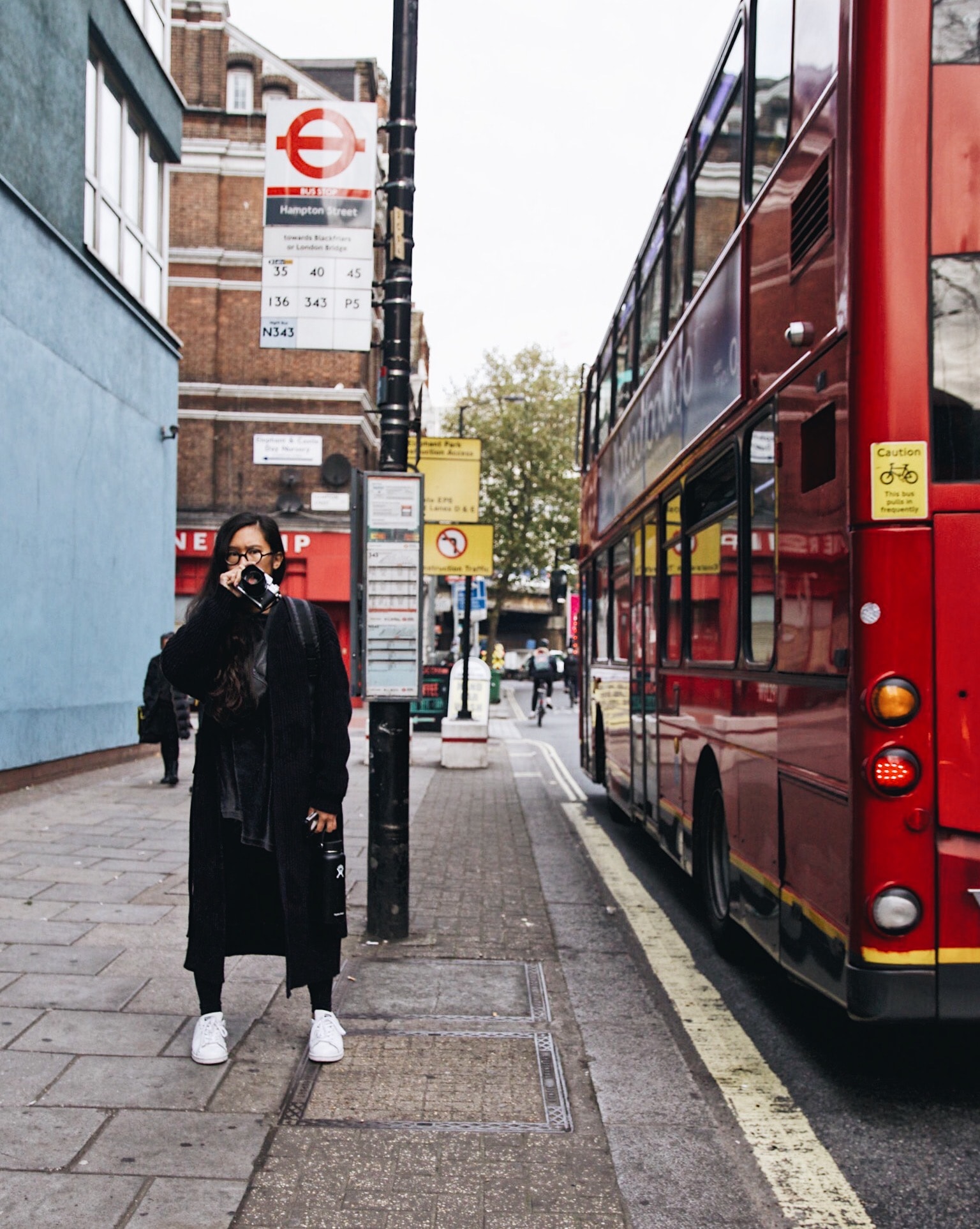 Advisor standing on the street in London next to a red double decker bus