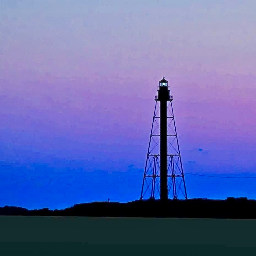 View of a deep purple and blue sky behind a tower in silhouette