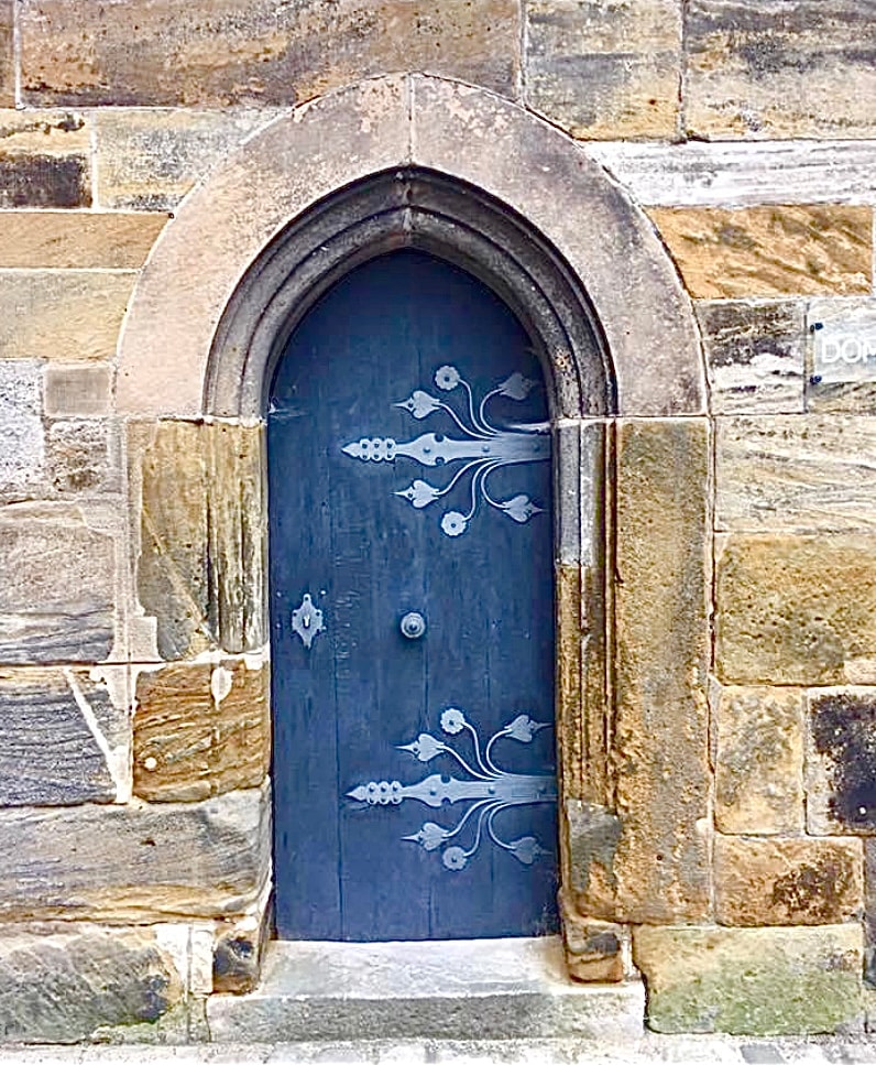 Blue wooden door set in an old stone wall