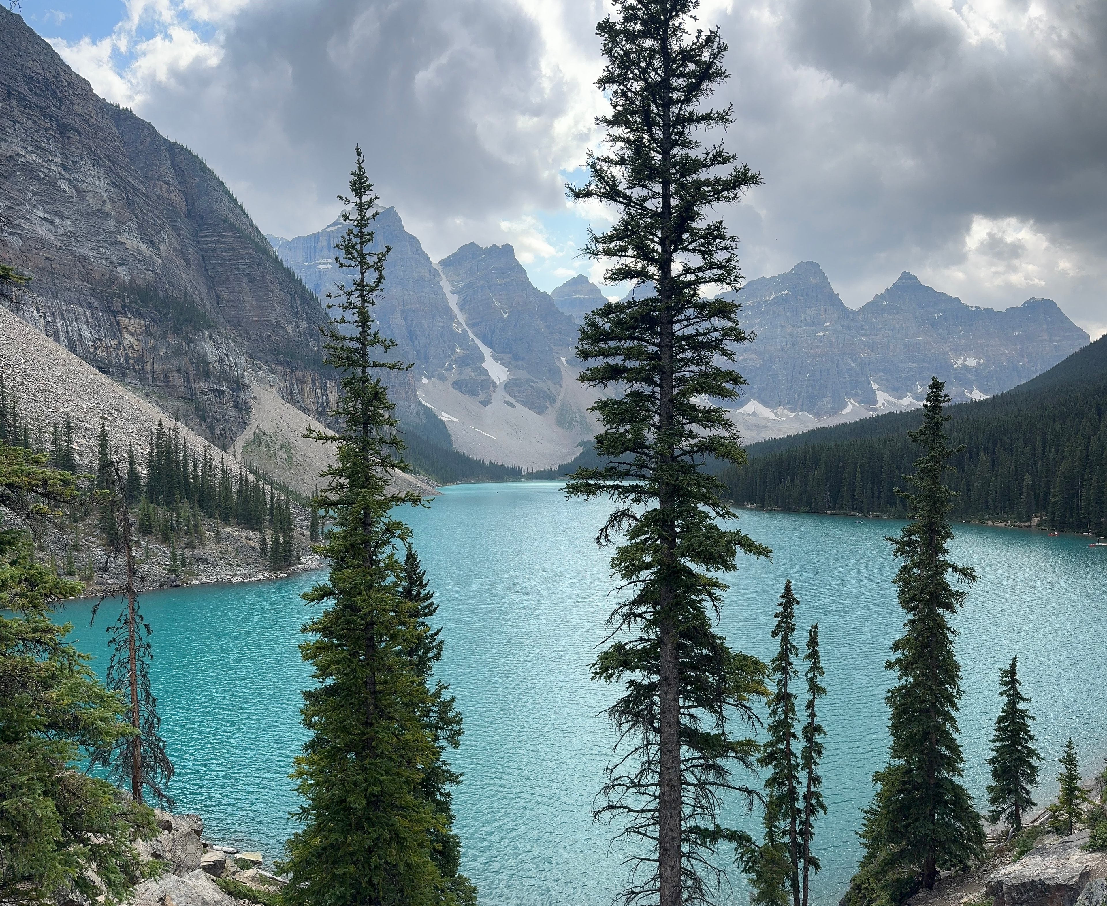 Gorgeous view of a blue glacial lake surrounded by dramatic mountains under partly cloudy skies