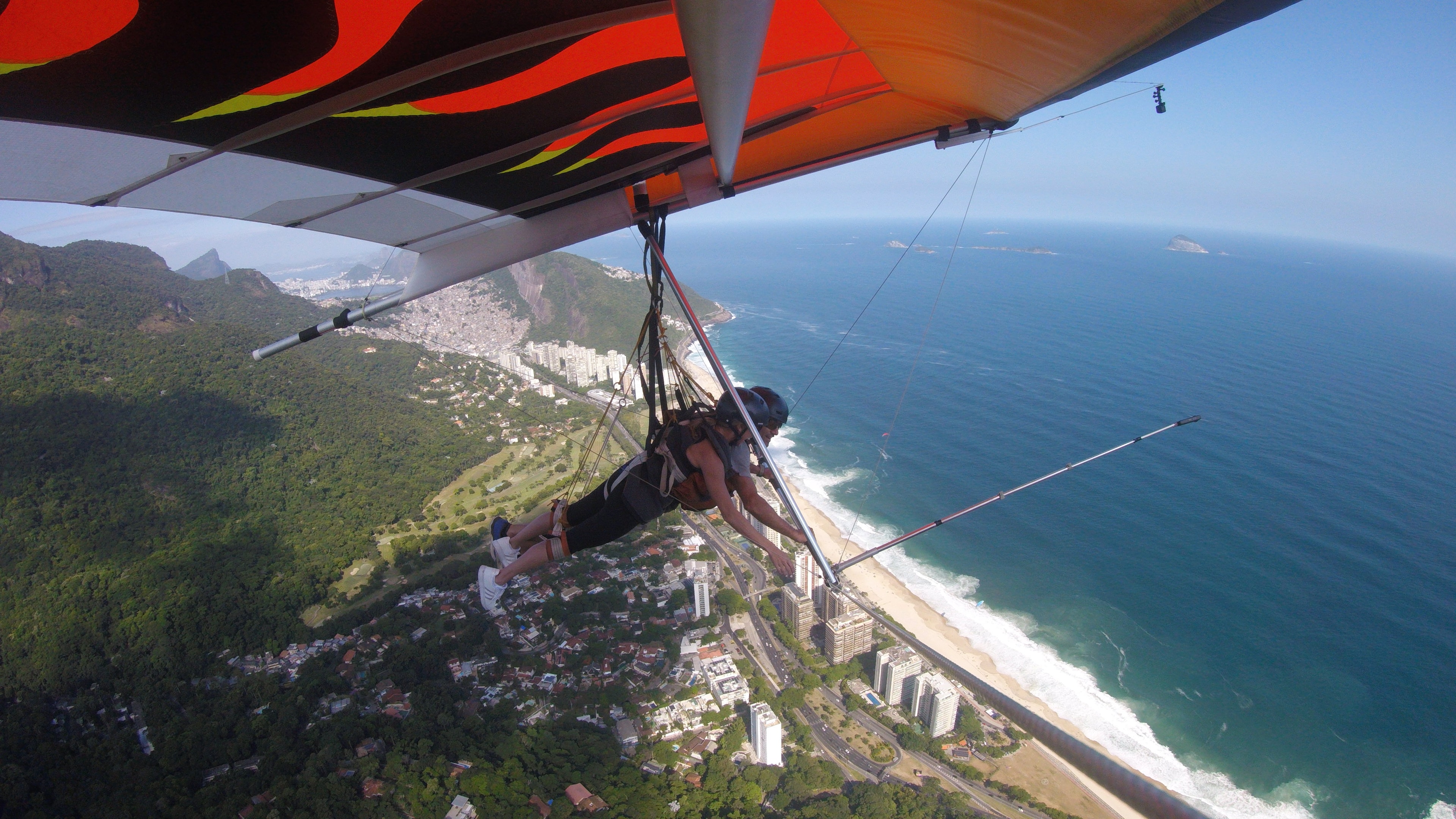 Jennifer paragliding above a cityscape, showcasing the vibrant urban environment below.