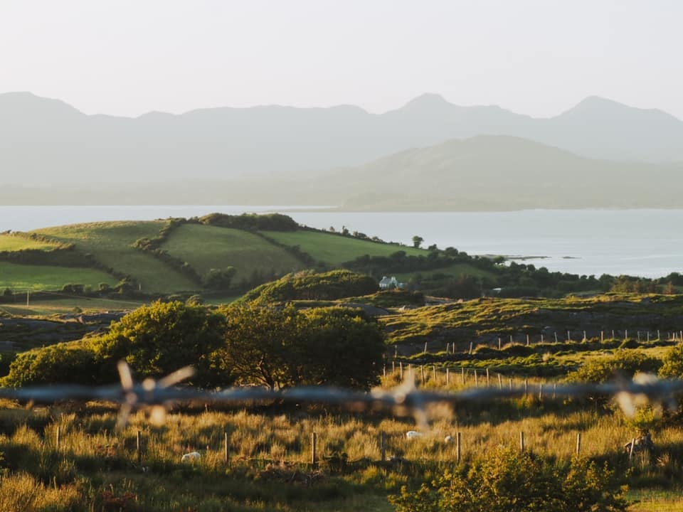 Beautiful view of the green countryside in Ireland with the sea in the distance