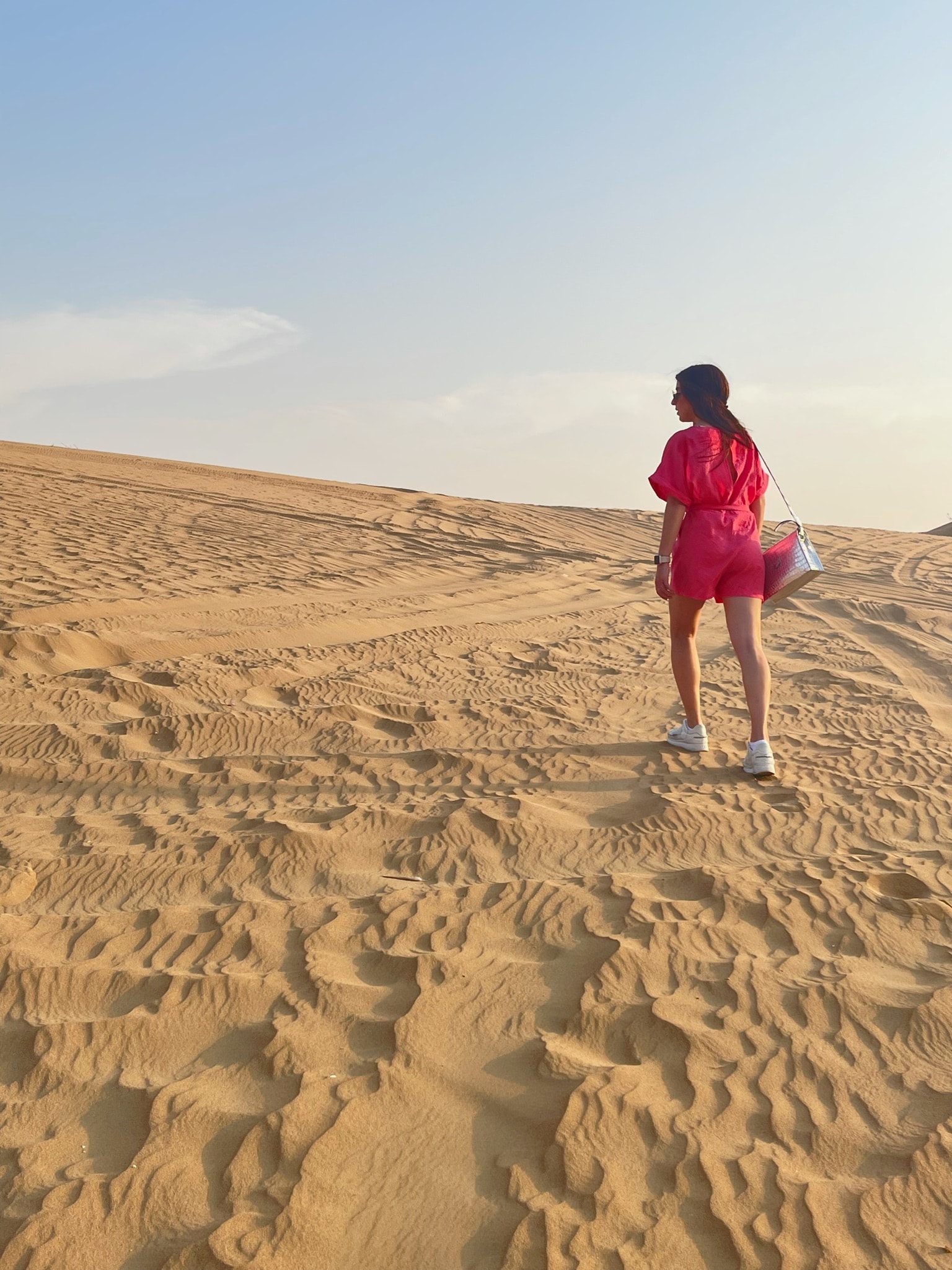 Advisor walking on a large empty expanse of sand on a clear day