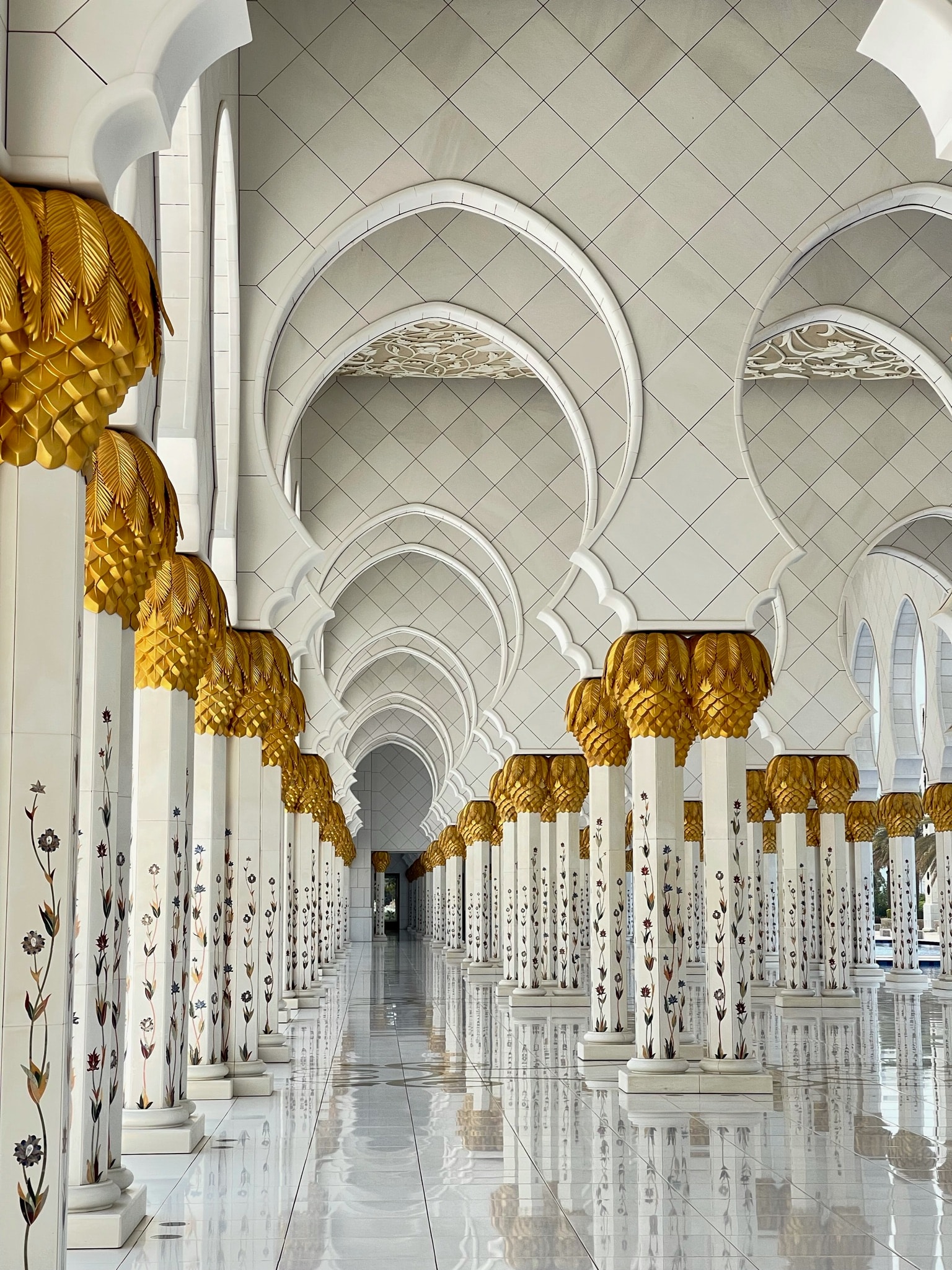 View of the interior of an ornate white temple with columns and arched ceilings