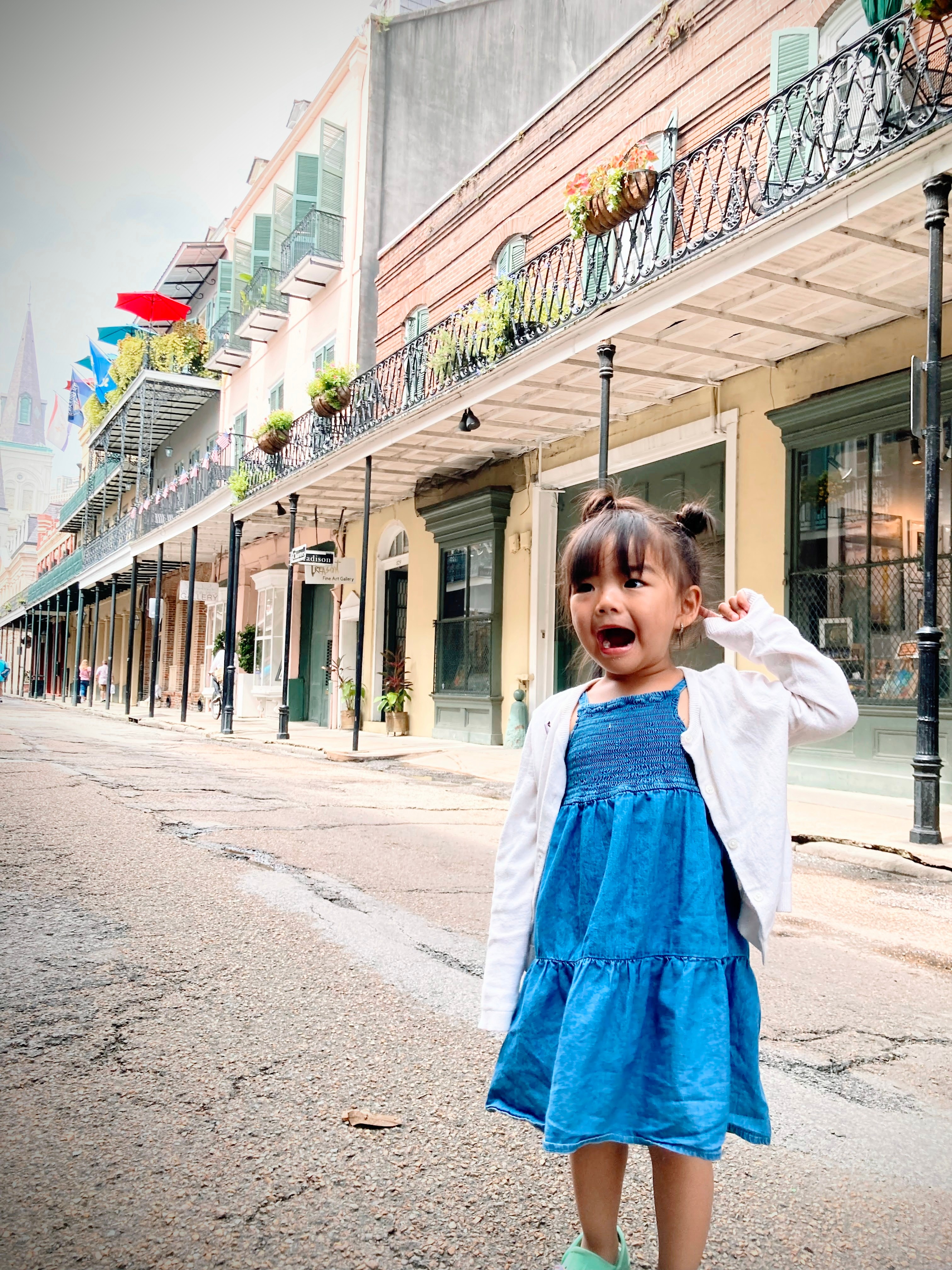 View of advisor’s daughter in a blue dress smiling on an empty city street