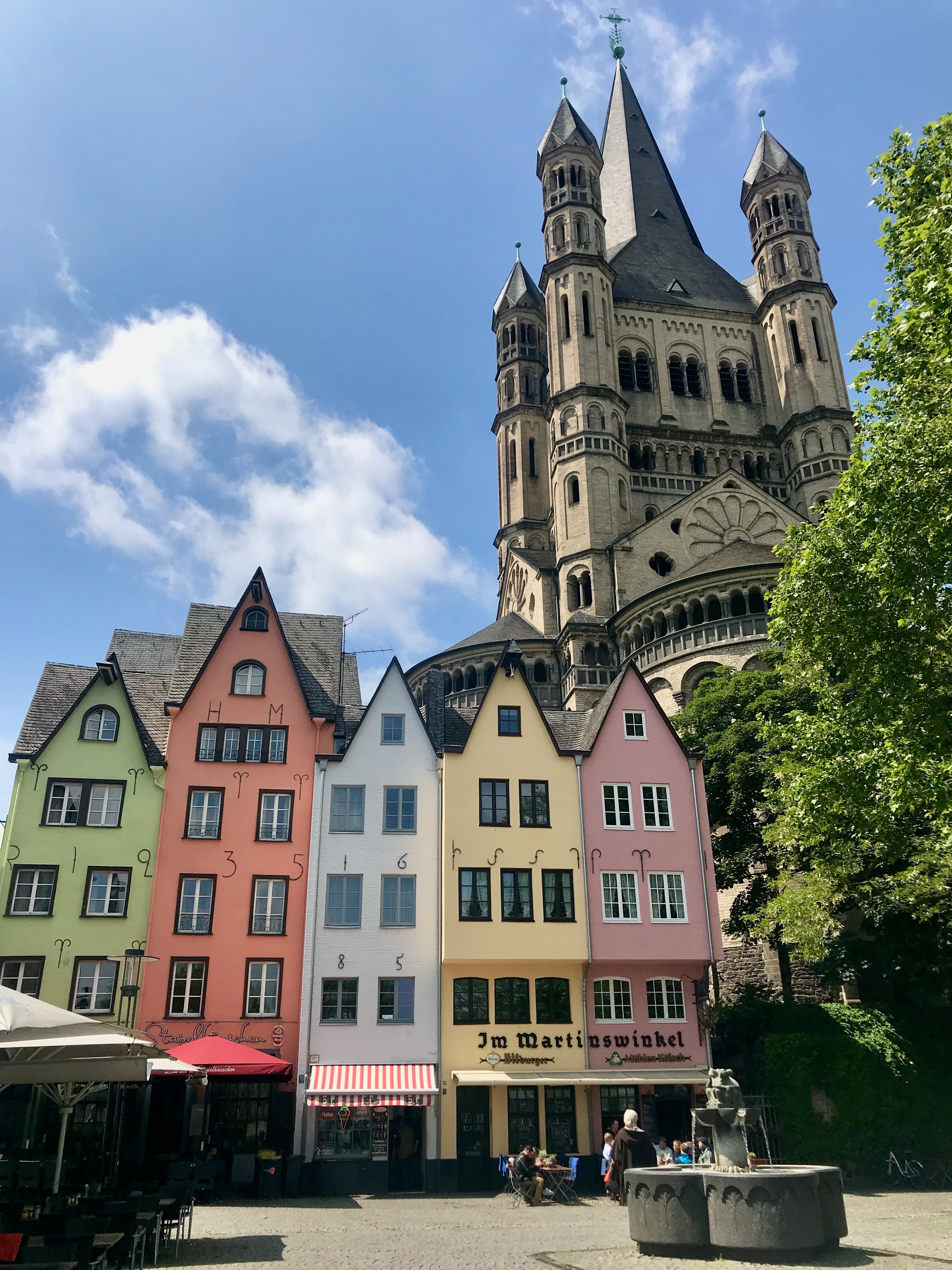 View of a colorful row of small houses with a beautiful cathedral towering above