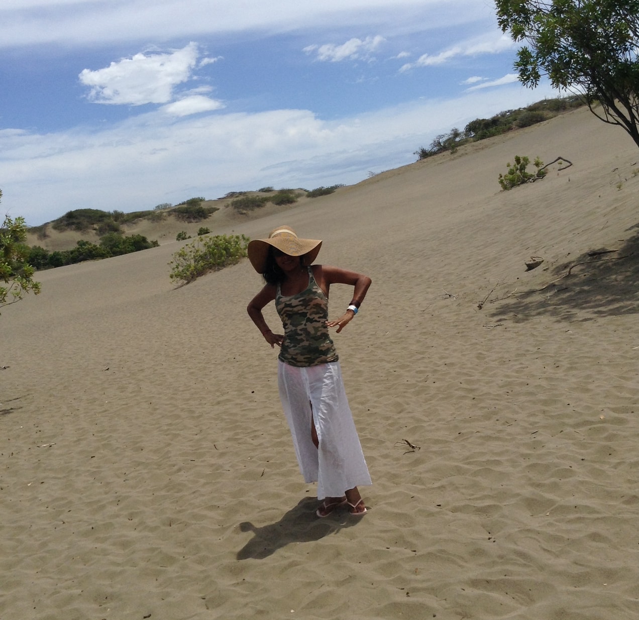 Advisor posing with hands on hips in a desert environment