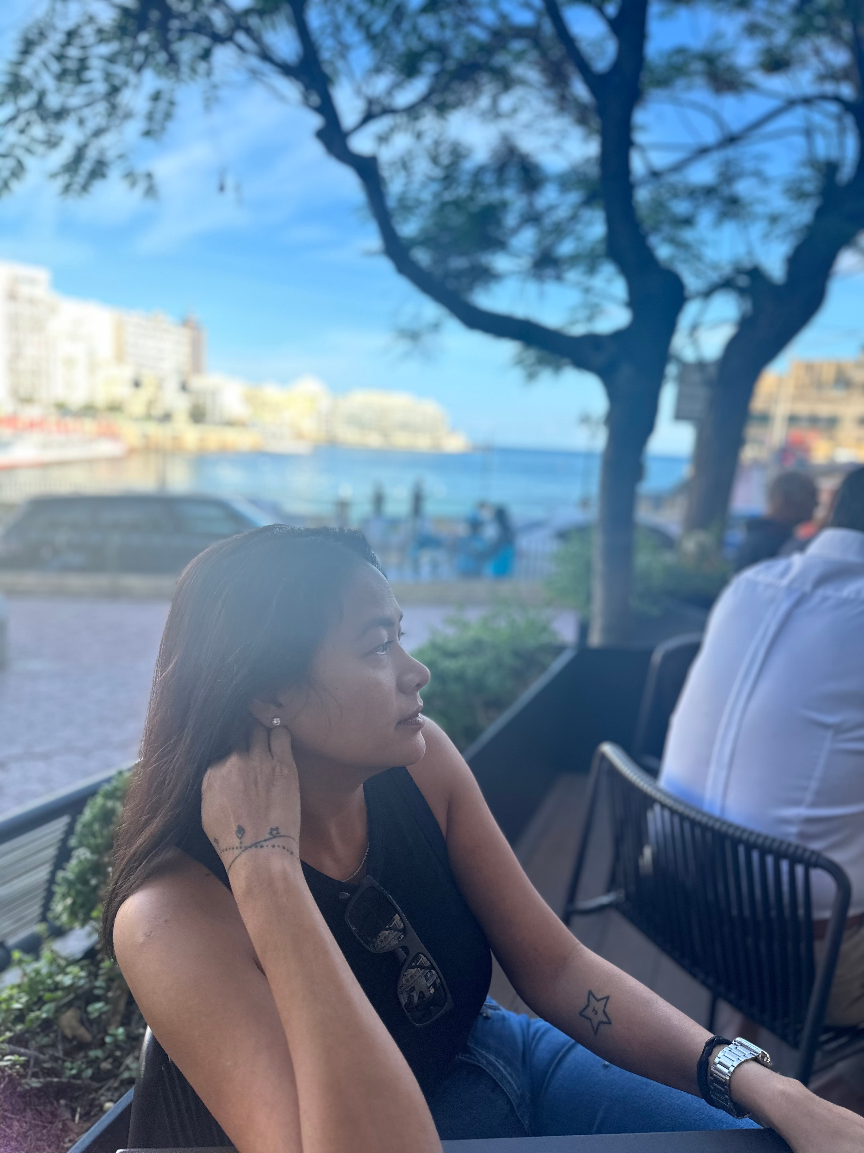 Advisor sitting outdoors at a restaurant with the sea visible in the distance 