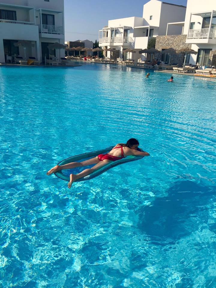 View of advisor lying face down on a raft in a large empty swimming pool