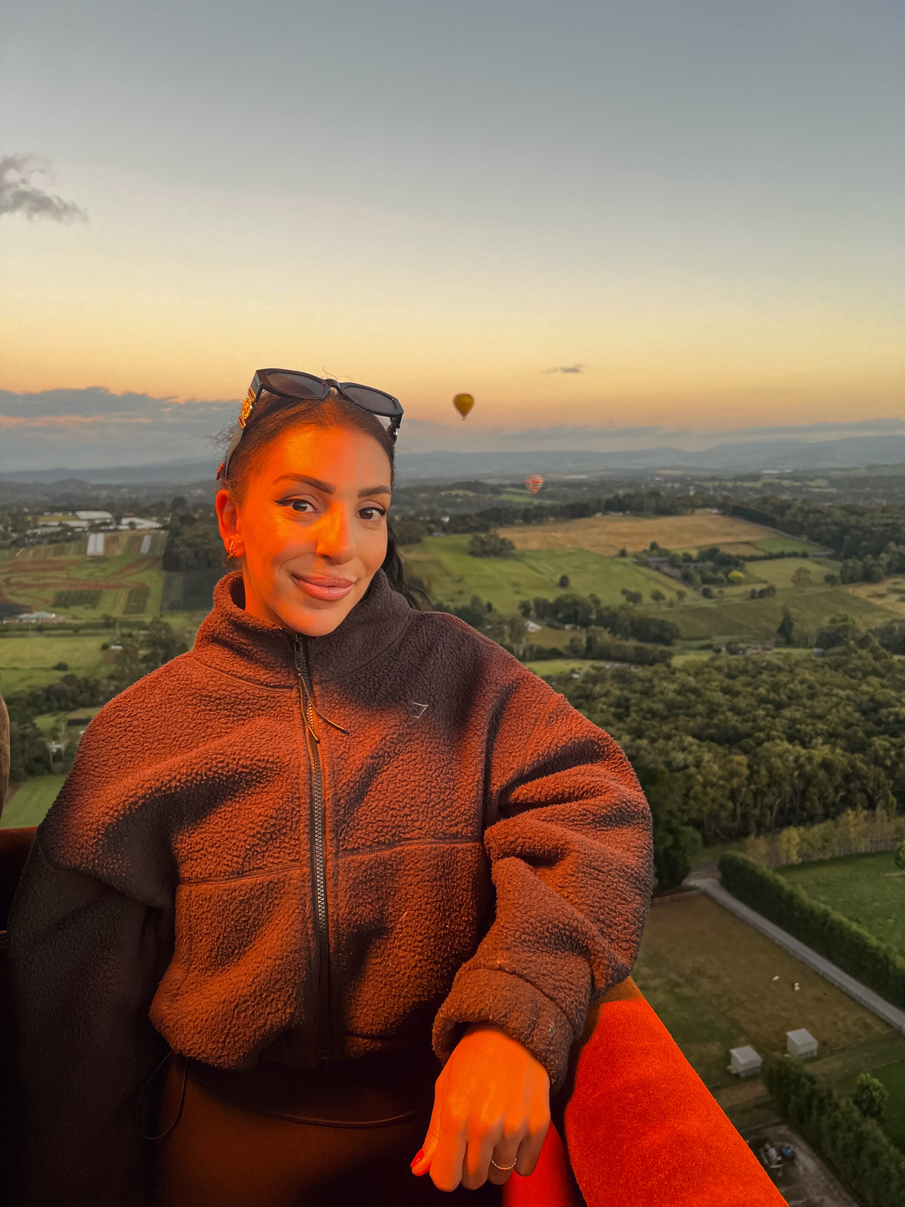 Advisor smiling while in a hot air balloon at sunrise