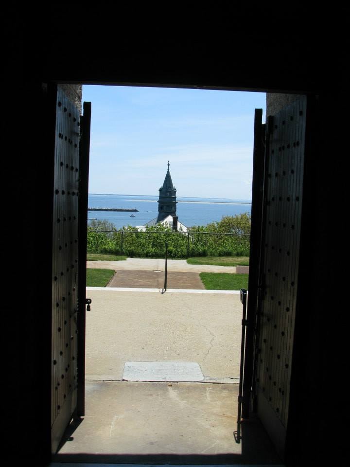 View of gardens and the distant sea visible through an open door